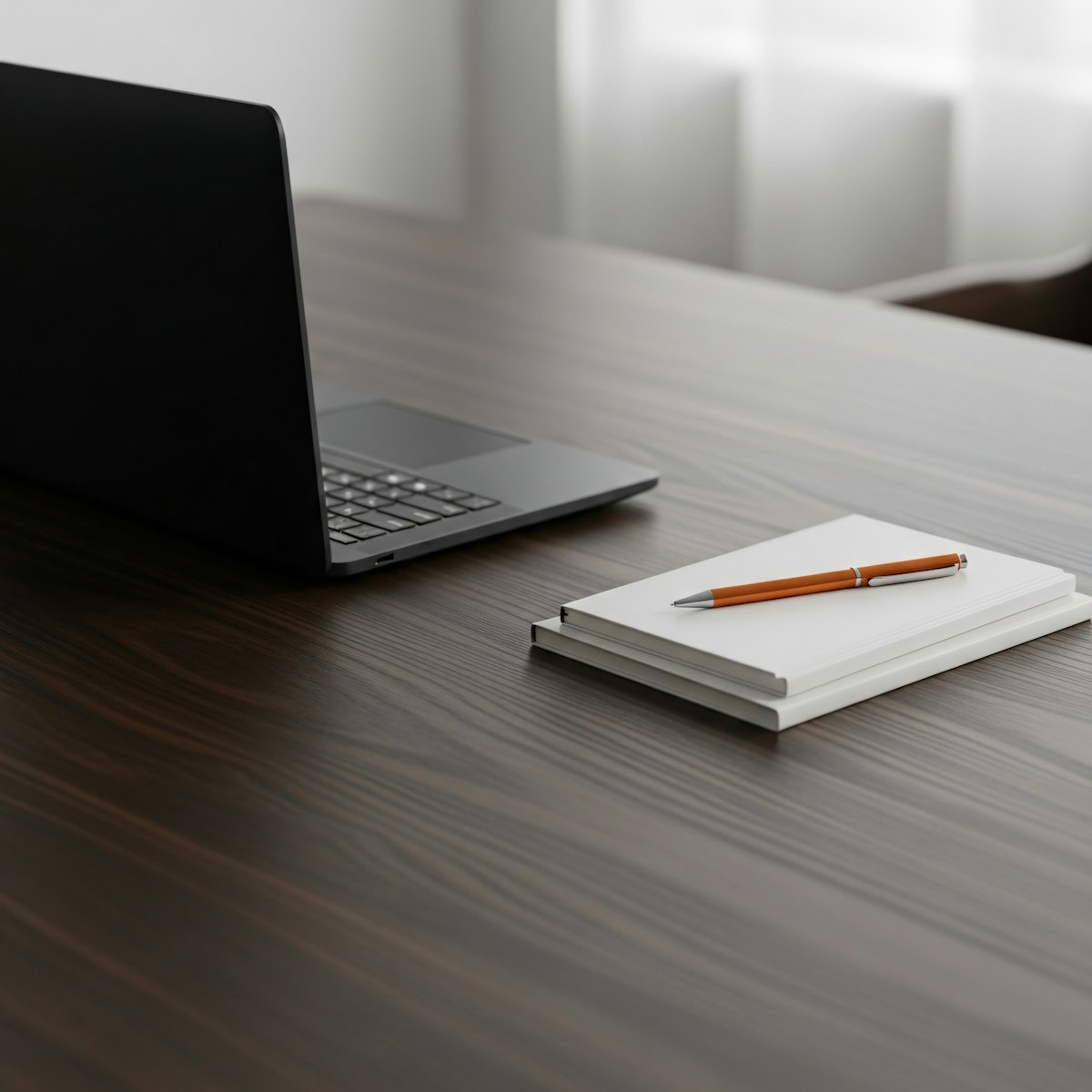 notebook beside laptop on desk