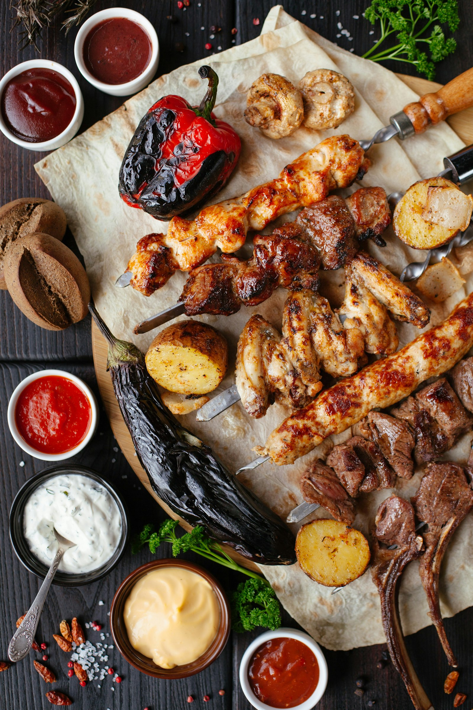A generous braai spread with skewers, roasted vegetables and sauces