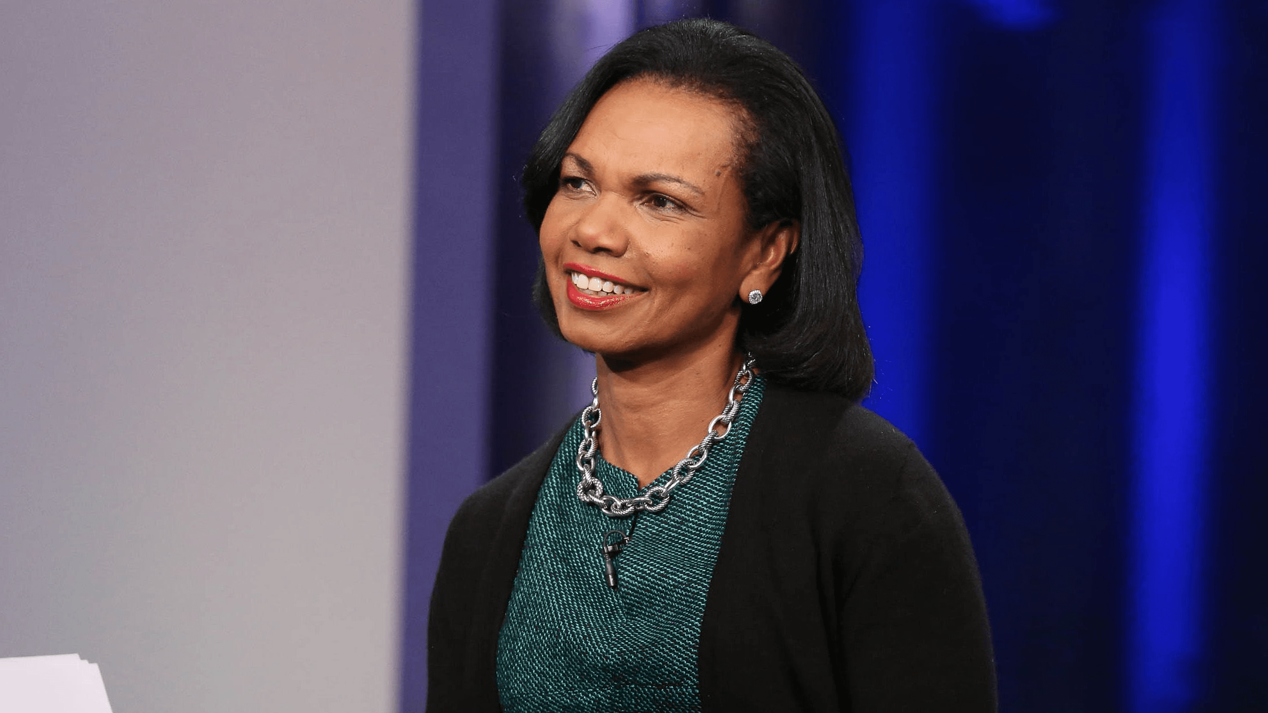 Minimalist profile shot of a man with long braids and a white shirt, set against a soft, light background.