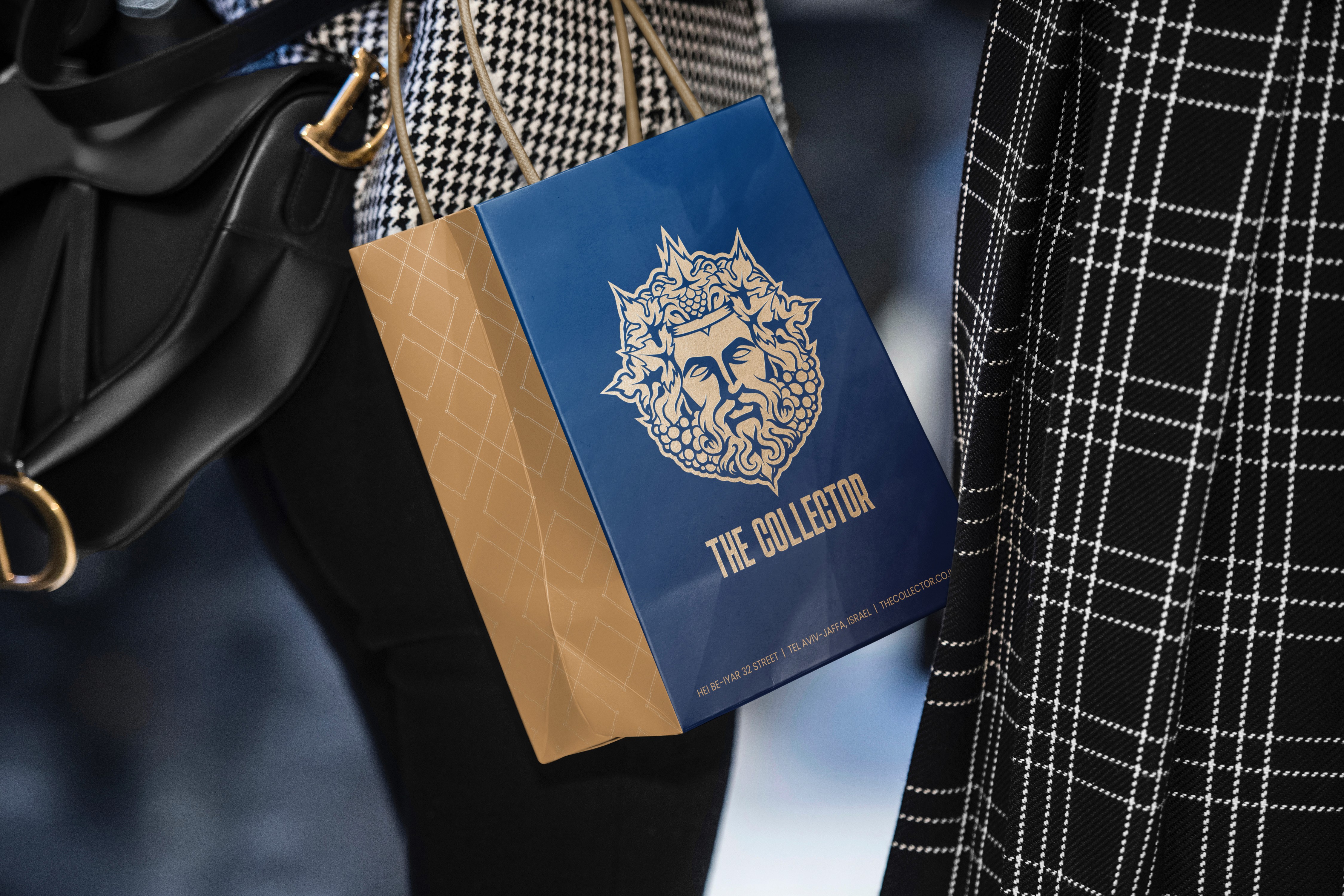 Luxury shopping bag with The Collector gold emblem logo in blue and gold premium retail packaging design.