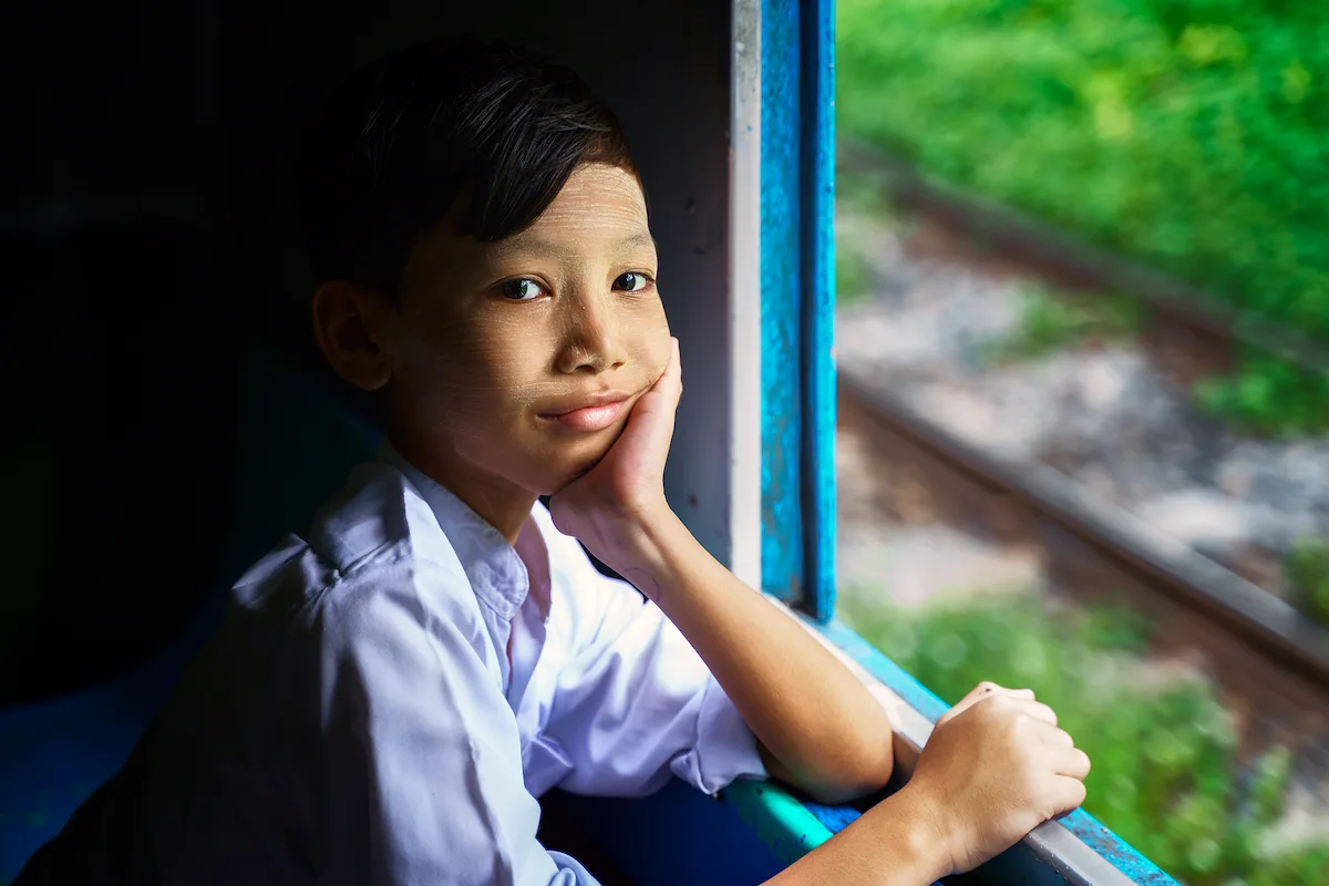 Niño con tanaka en la cara en un tren de Myanmar
