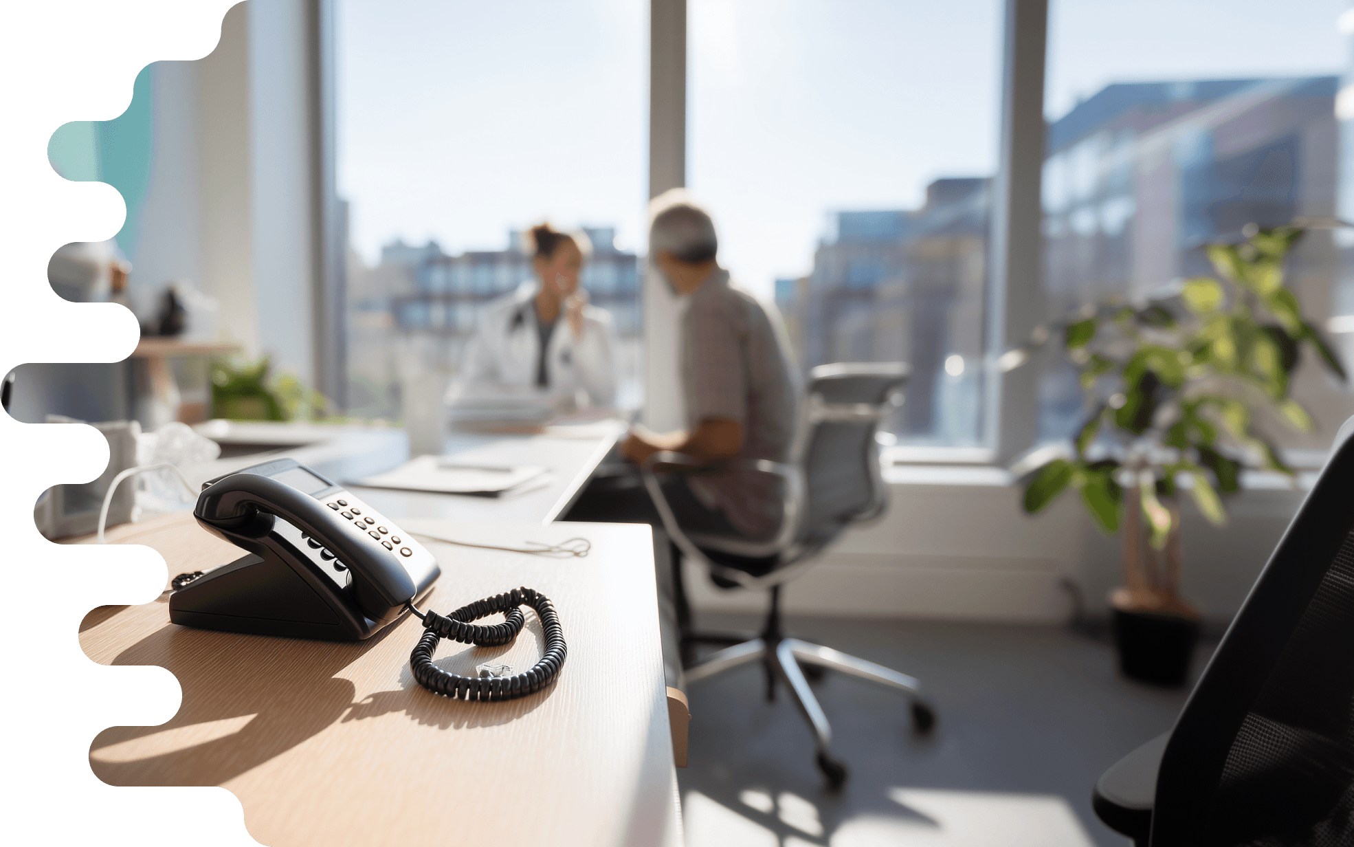 In a bright doctor's office, a doctor in white clothing is sitting and talking with a patient. The patient, a middle-aged man with short gray hair, listens attentively. In the foreground of the image, a black telephone lies on a wooden desk. The cord of the telephone is slightly tangled. On the desk, there are more medical documents and a laptop visible, while large windows in the background flood the room with natural light. In front of the windows, modern buildings and a plant can be seen, bringing fresh greenery into the room. The entire scene conveys a friendly and professional atmosphere.