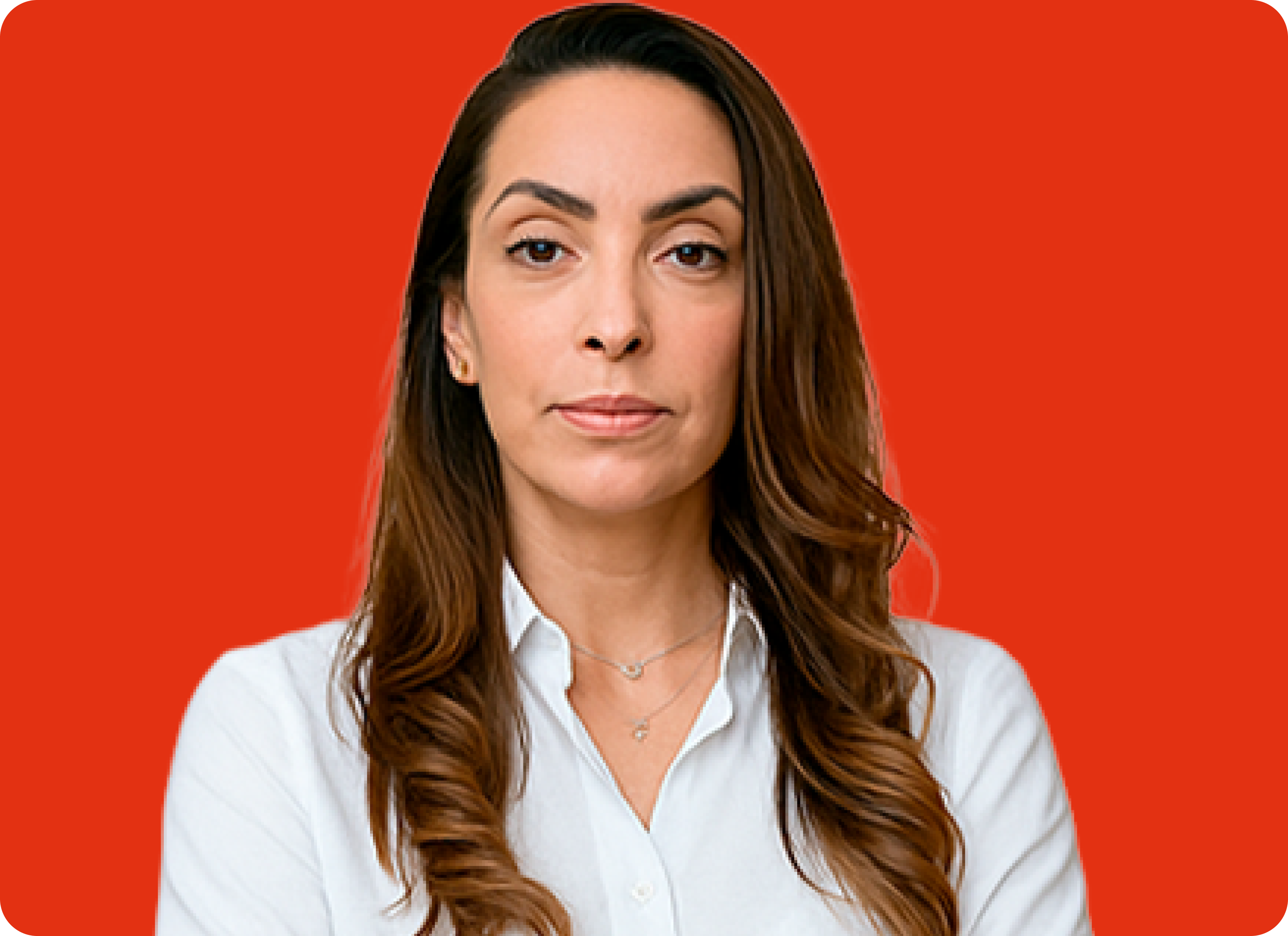 A winding road cuts through rocky terrain, surrounded by patches of green grass and illuminated by sunlight.