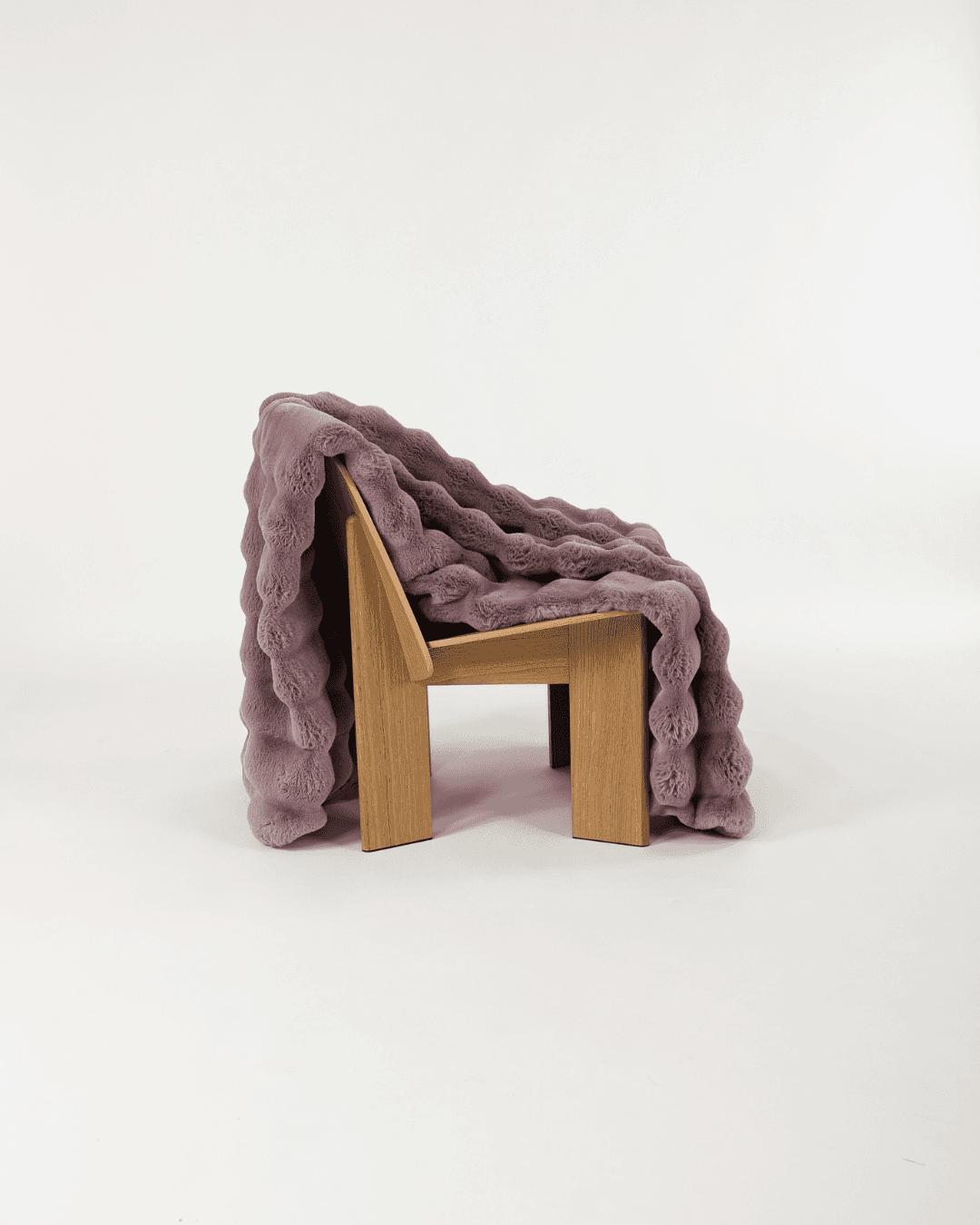 Dimensional faux fur blanket in lilac draped on wooden chair