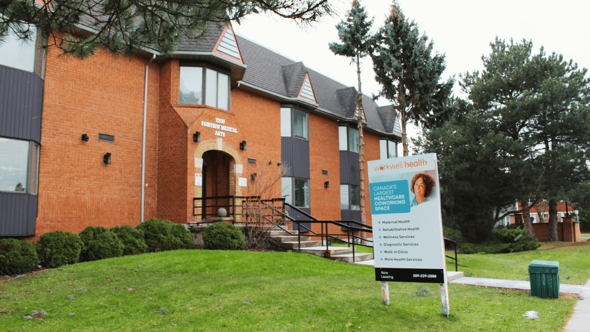 person wearing lavatory gown with green stethoscope on neck using phone while standing