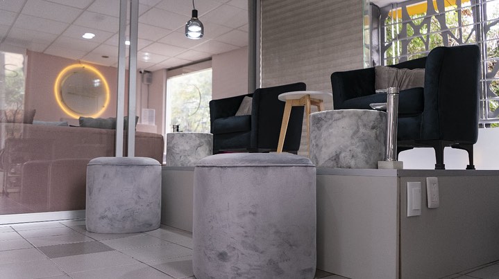 A serene spa setting with two lounge chairs beside a warm, reflective pool and soft, natural lighting.