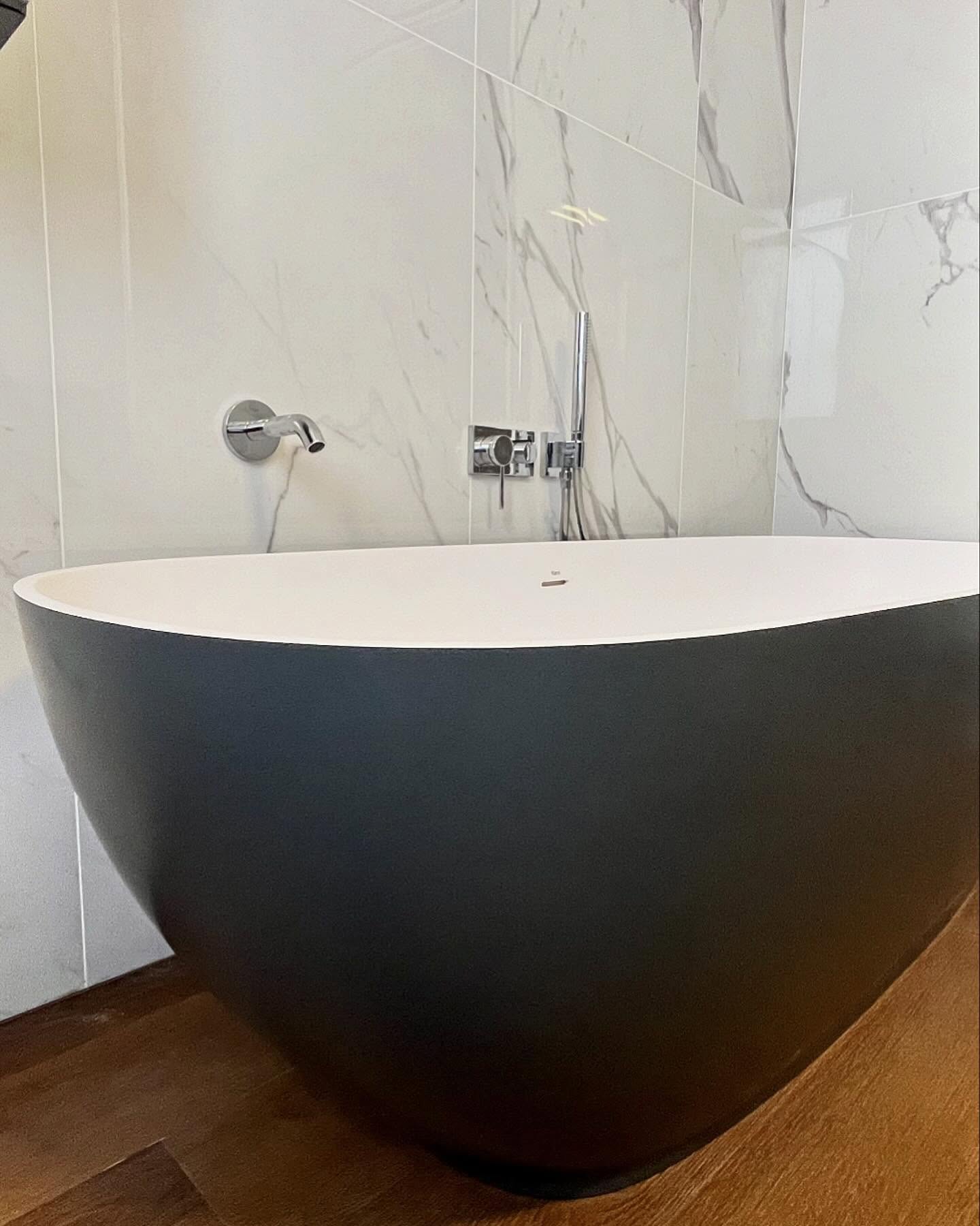 dettaglio vasca da bagno di lusso con pareti rifinite in marmo e pavimenti in parquet