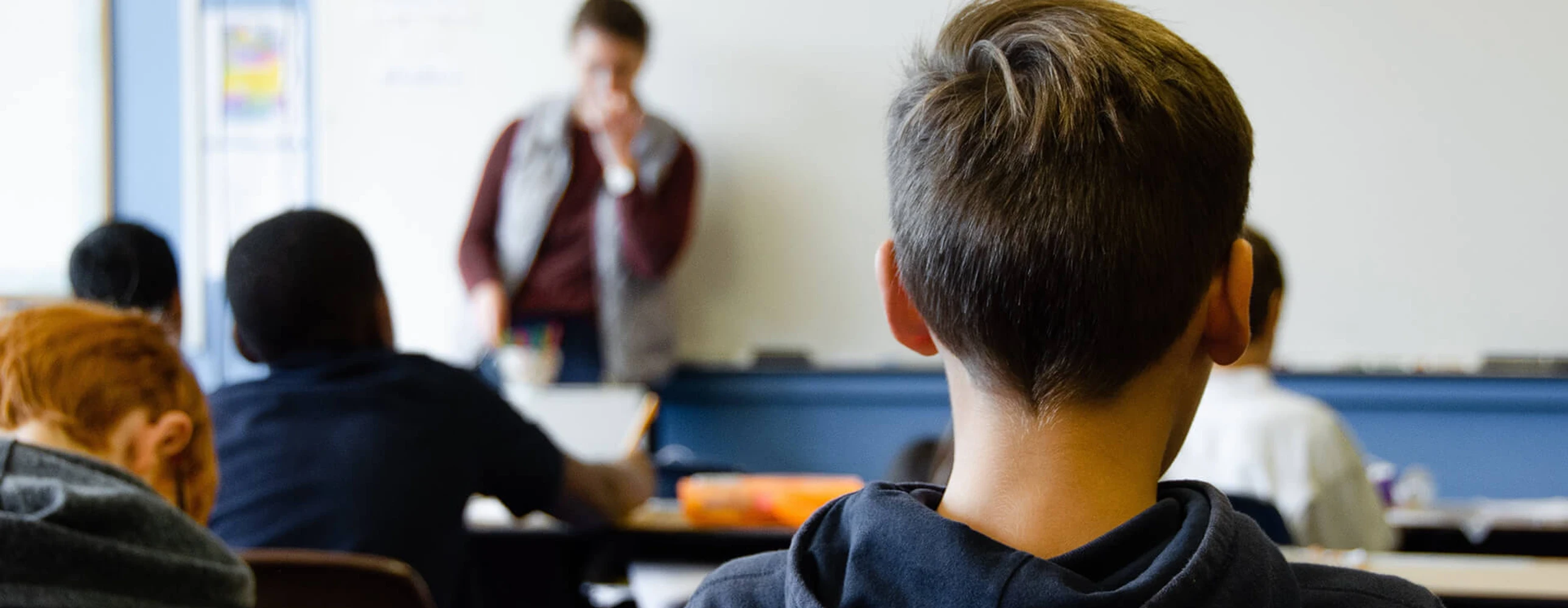 person in red sweater holding babys hand