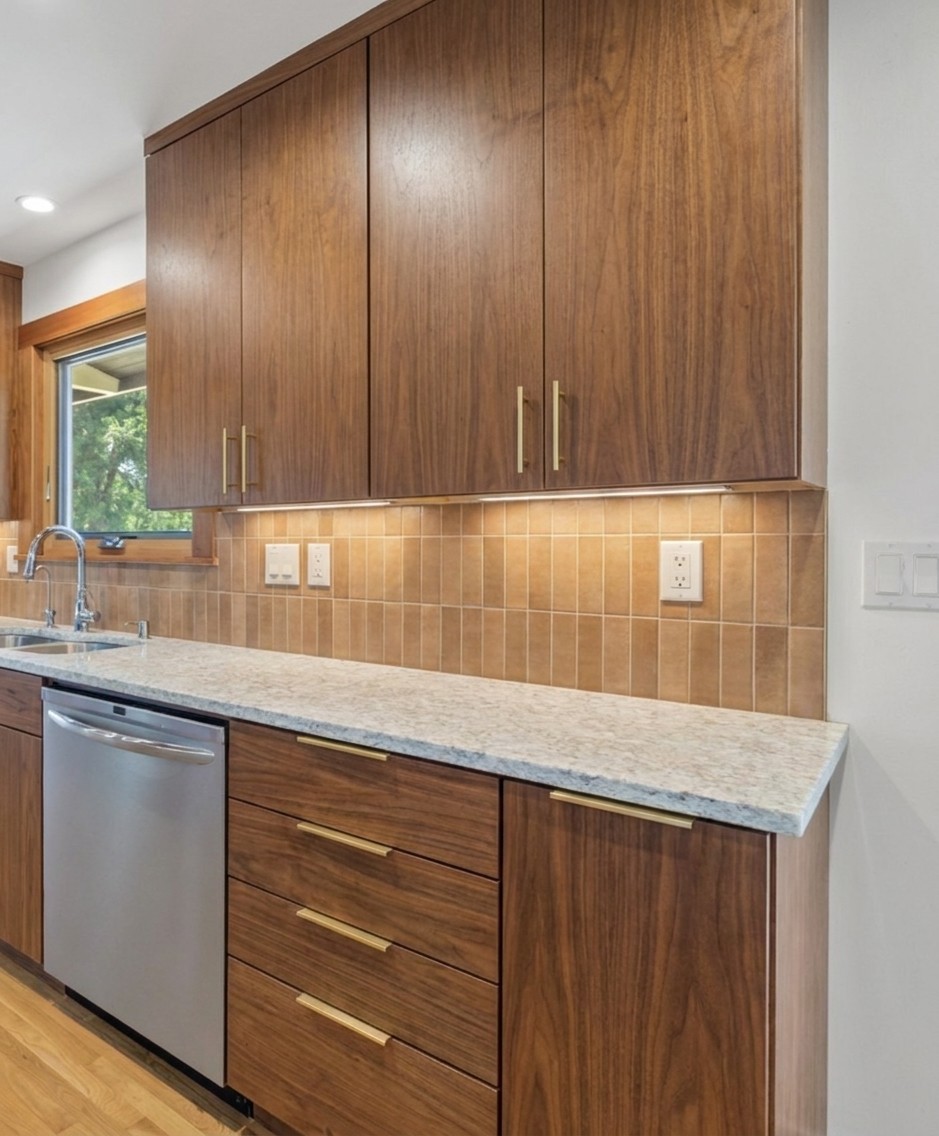 Walnut MCM — flat slab doors in the same walnut, no crown molding, brass bar pulls