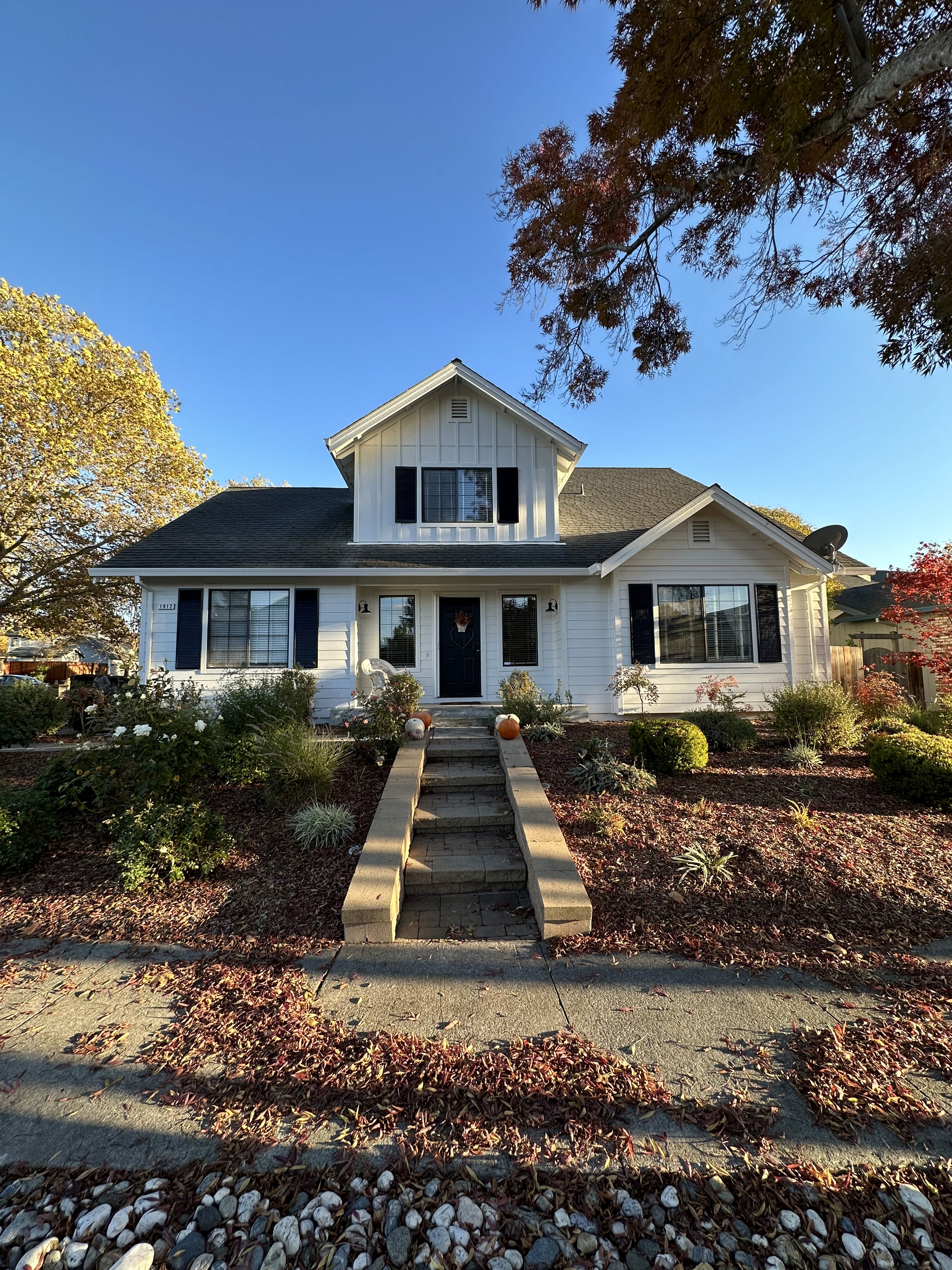 Completed premium exterior remodel with white siding and black trim