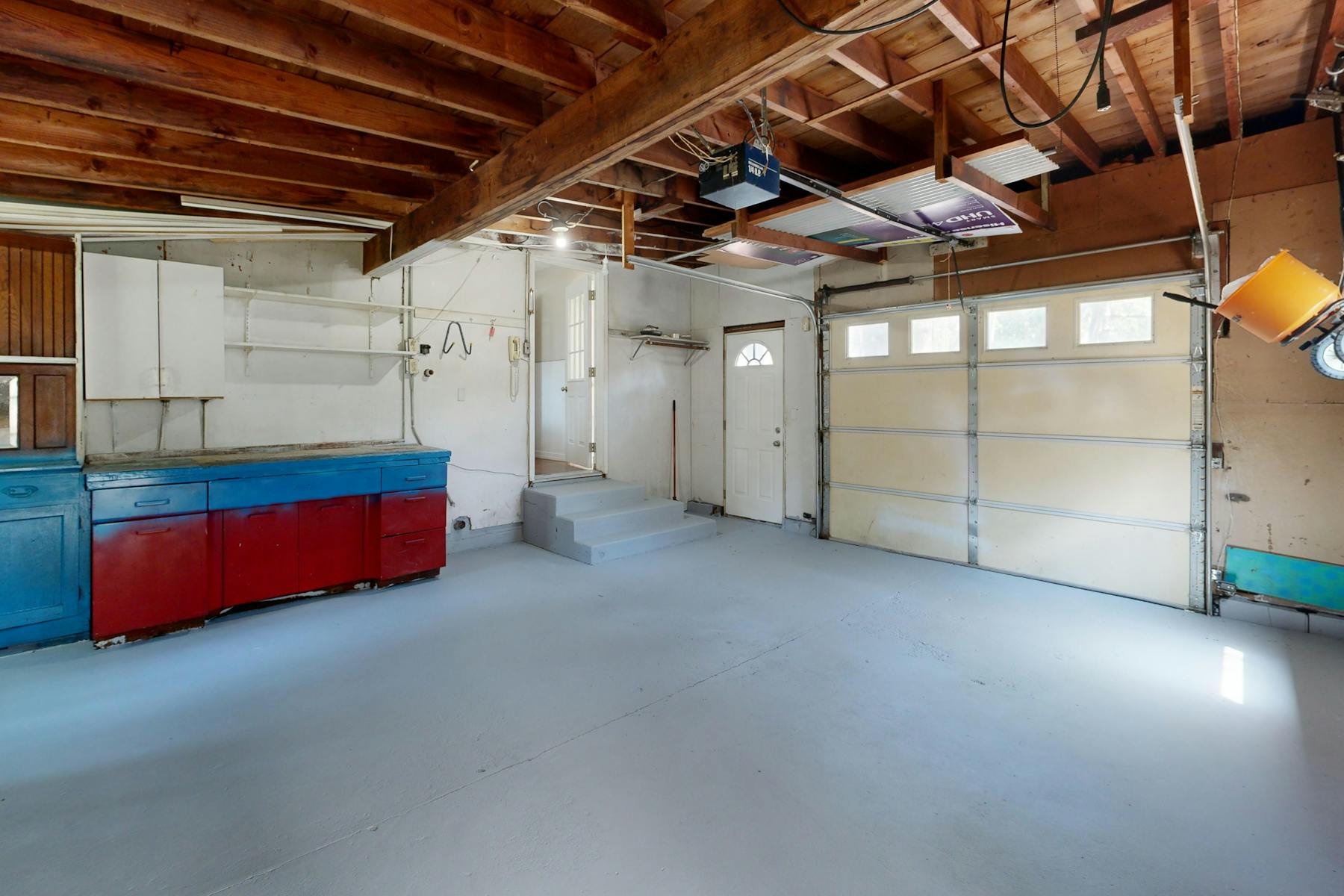 Clean, mostly empty garage with cabinets and open floor space