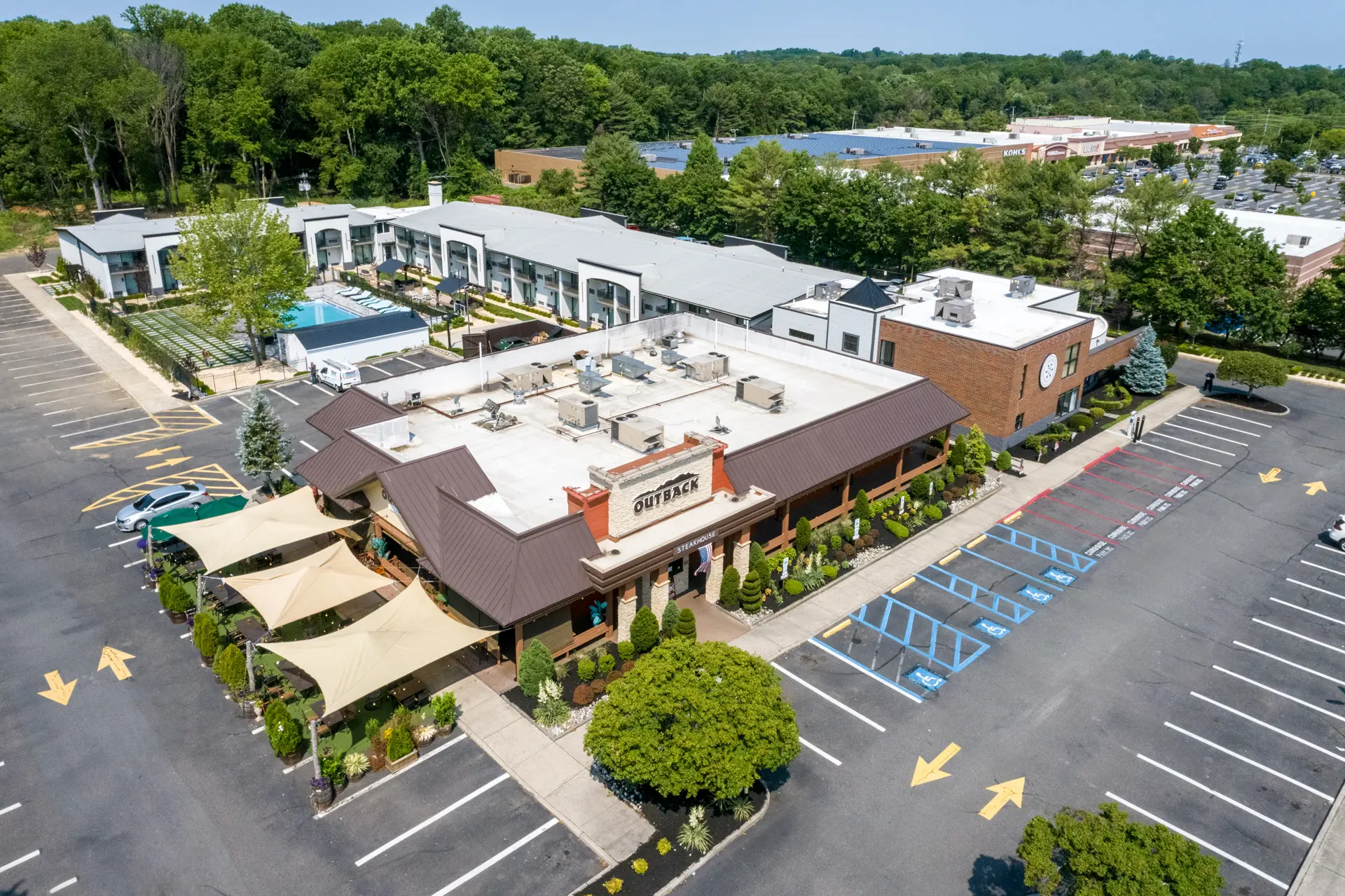 Aerial view of an Outback Steakhouse restaurant with parking lot and surrounding buildings.