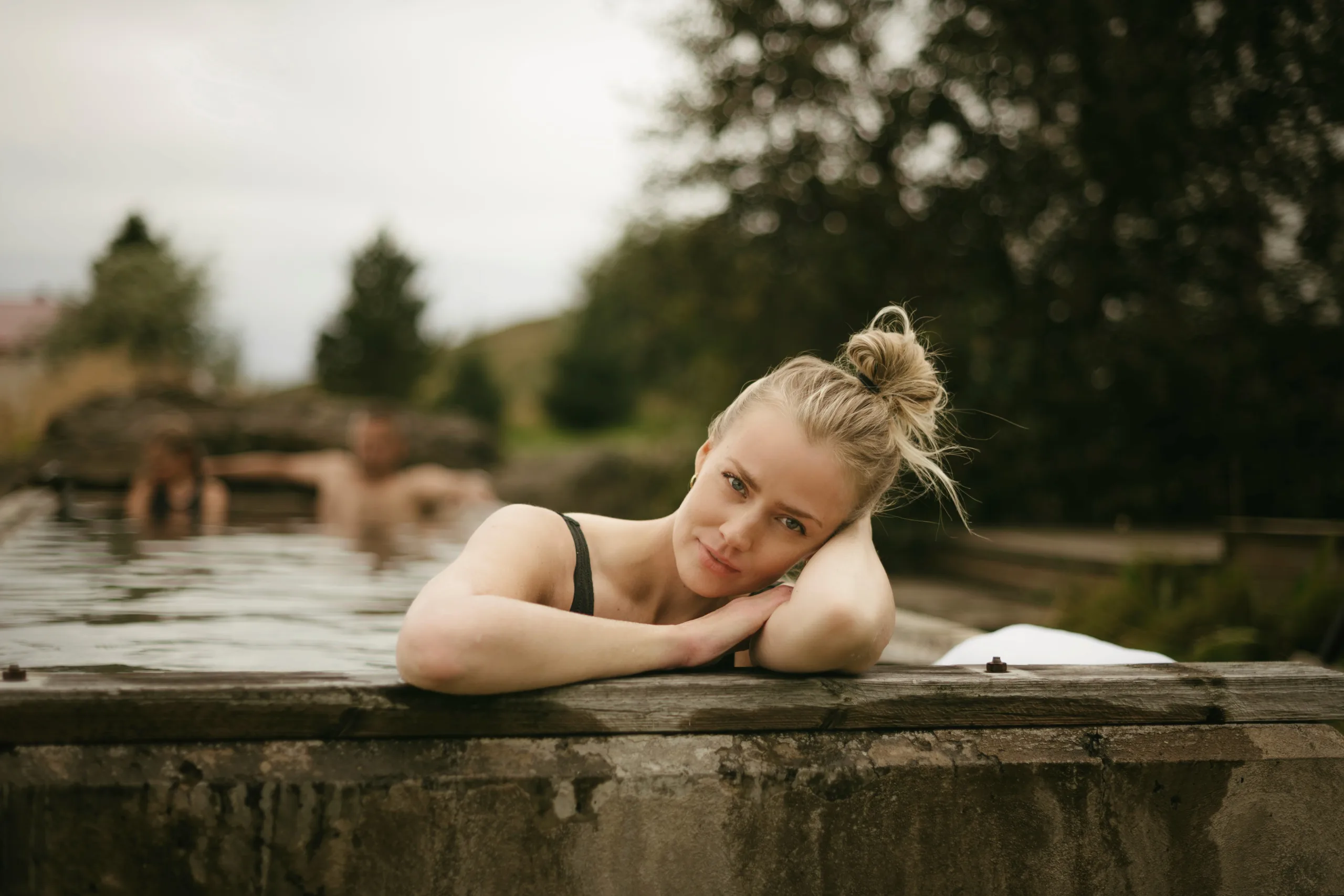 Guest resting at the edge of an outdoor geothermal hot spring pool