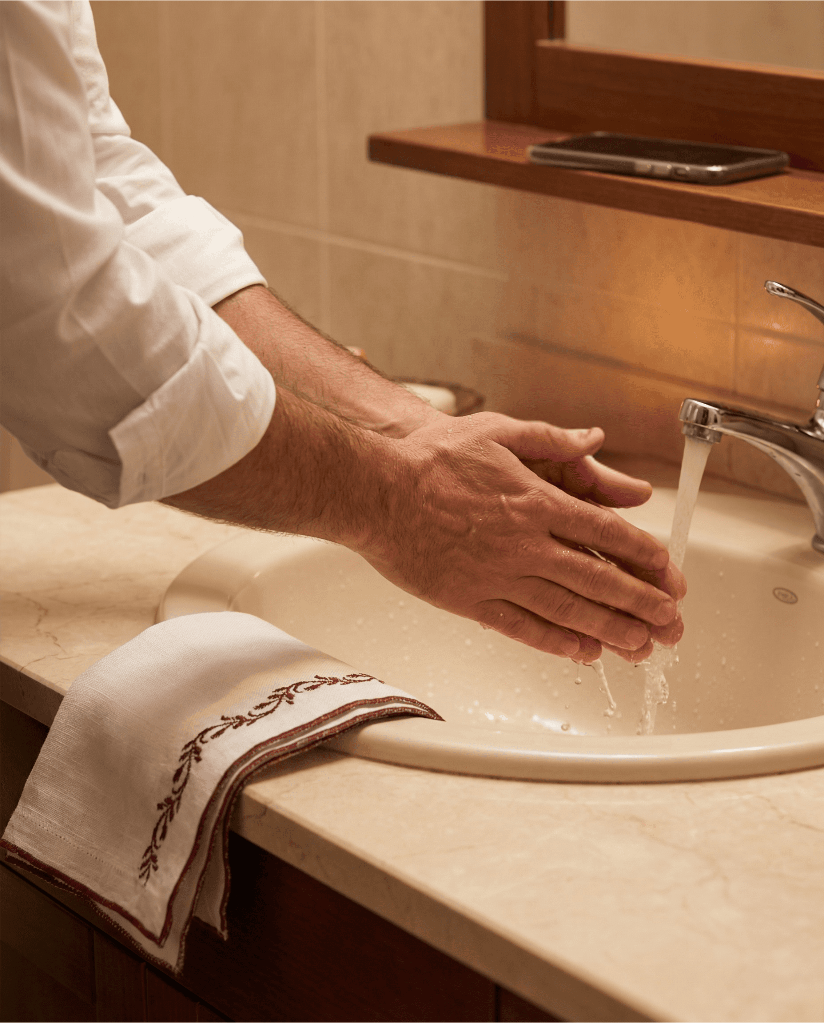 A circle of people sitting cross-legged, meditating with hands in a prayer position. Soft, warm lighting.