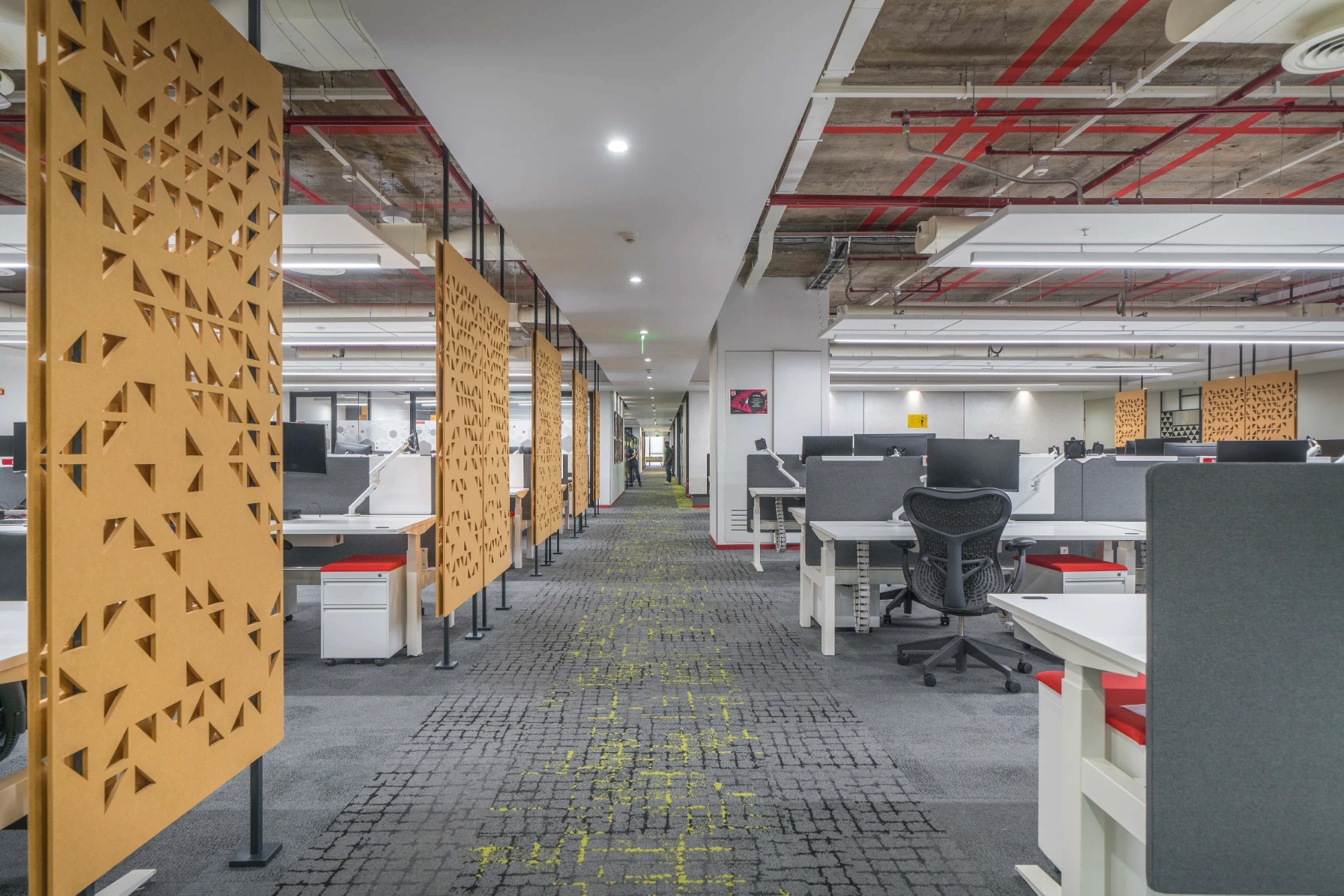 Walk way passage of work station area designed by open grid ceiling and pet panels on the side and carpet on the floor