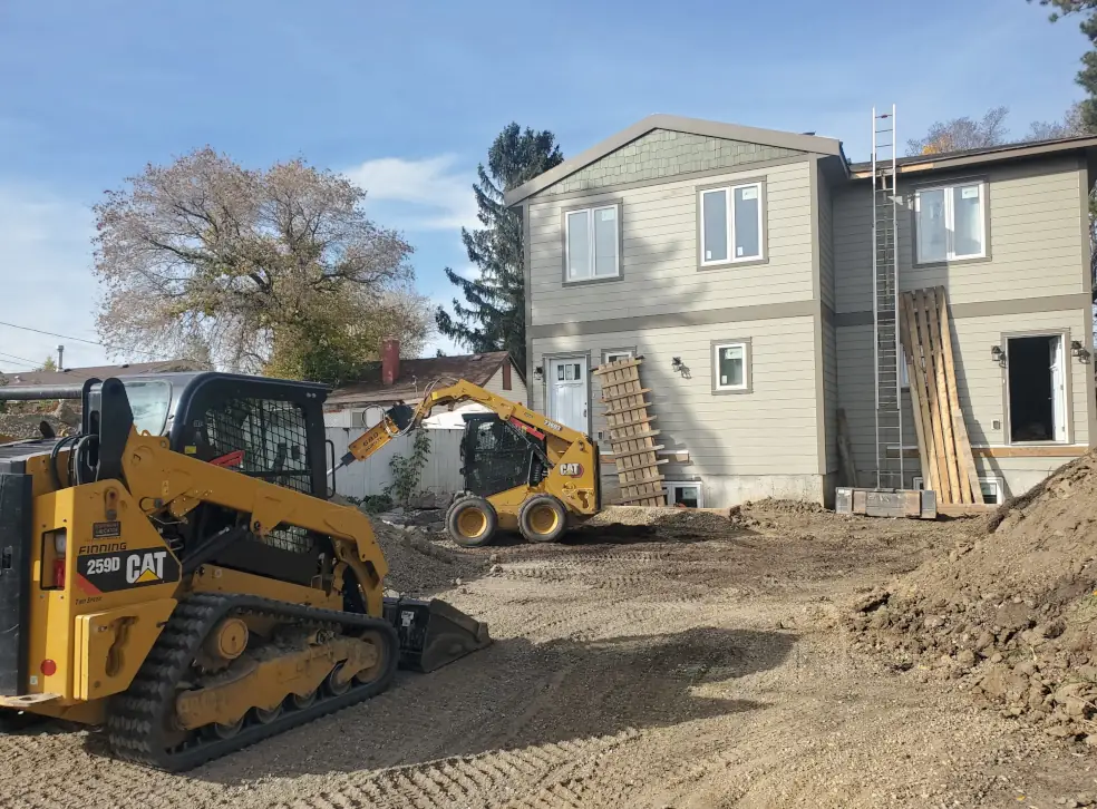 Skid steer making a garage pad in Parkland County