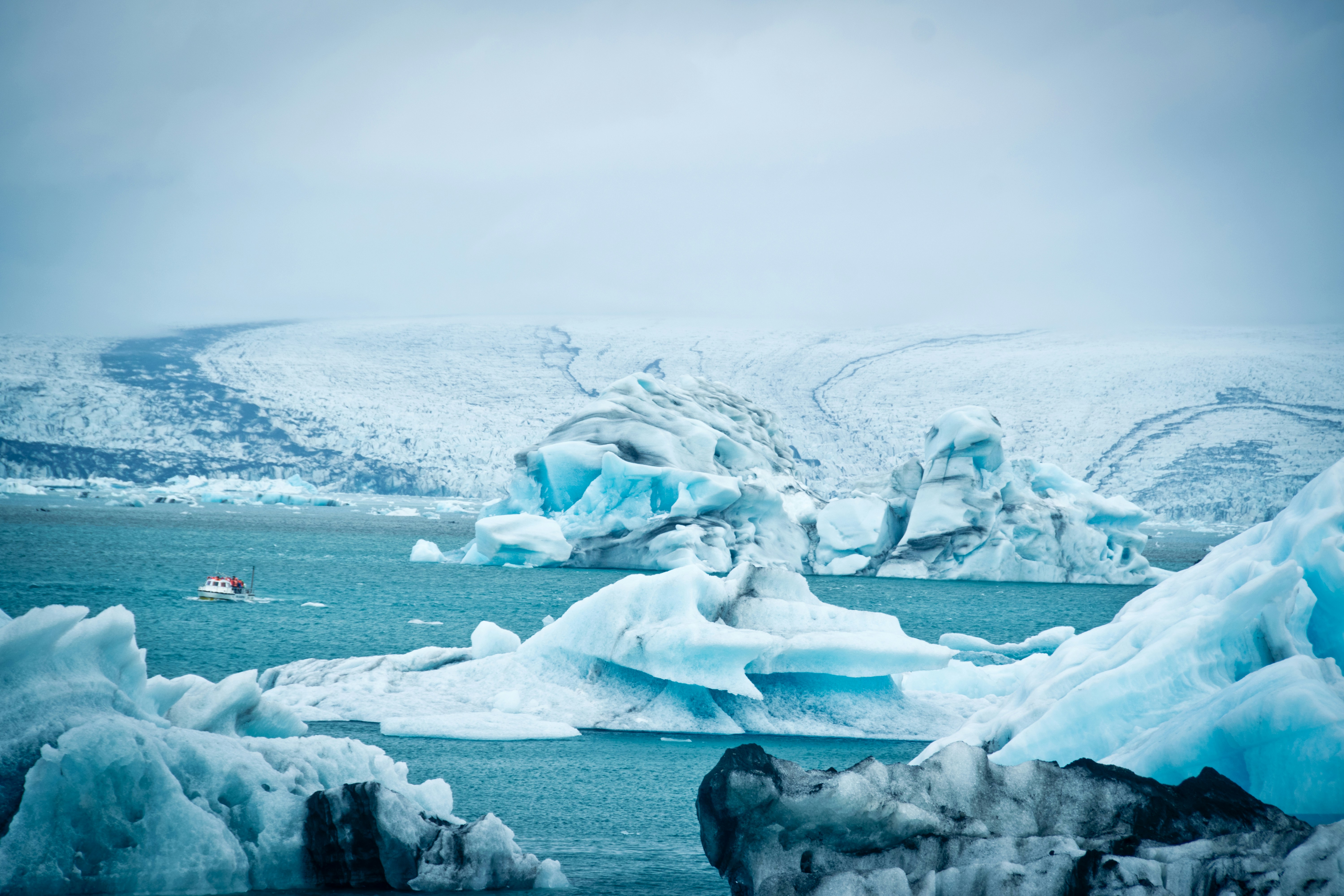 Boat navigating between icebergs at Jökulsárlón Glacier Lagoon in South Iceland.