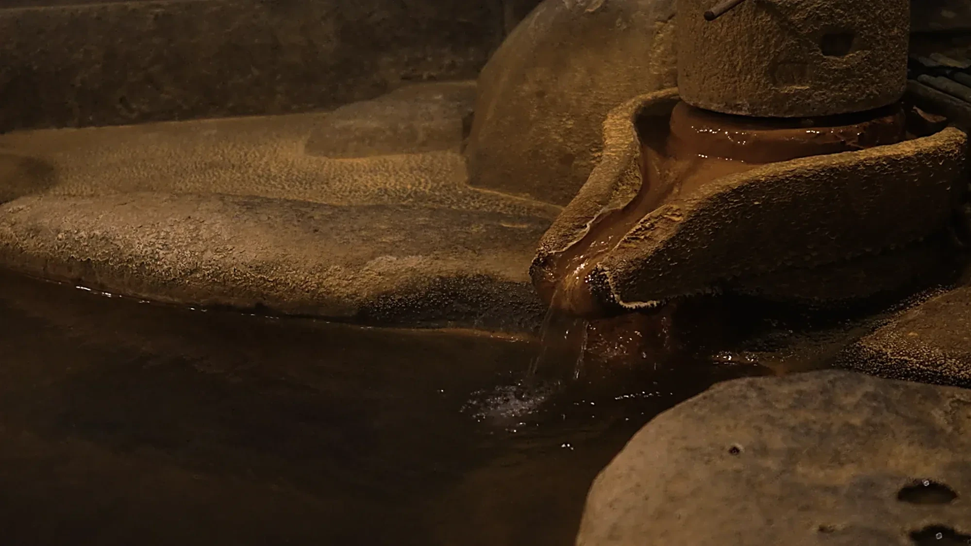 Hot spring water running over a stone lip into a rock pool