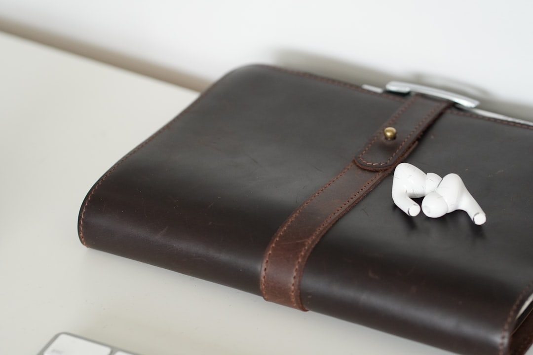 Brown leather notebook with white earbuds on top