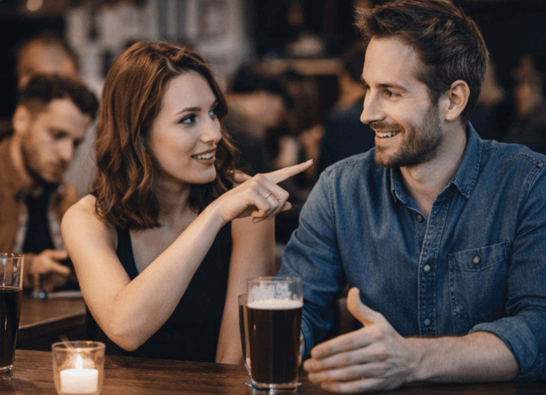 eine frau zeigt mit dem finger auf einen mann, beide sitzen in einer bar