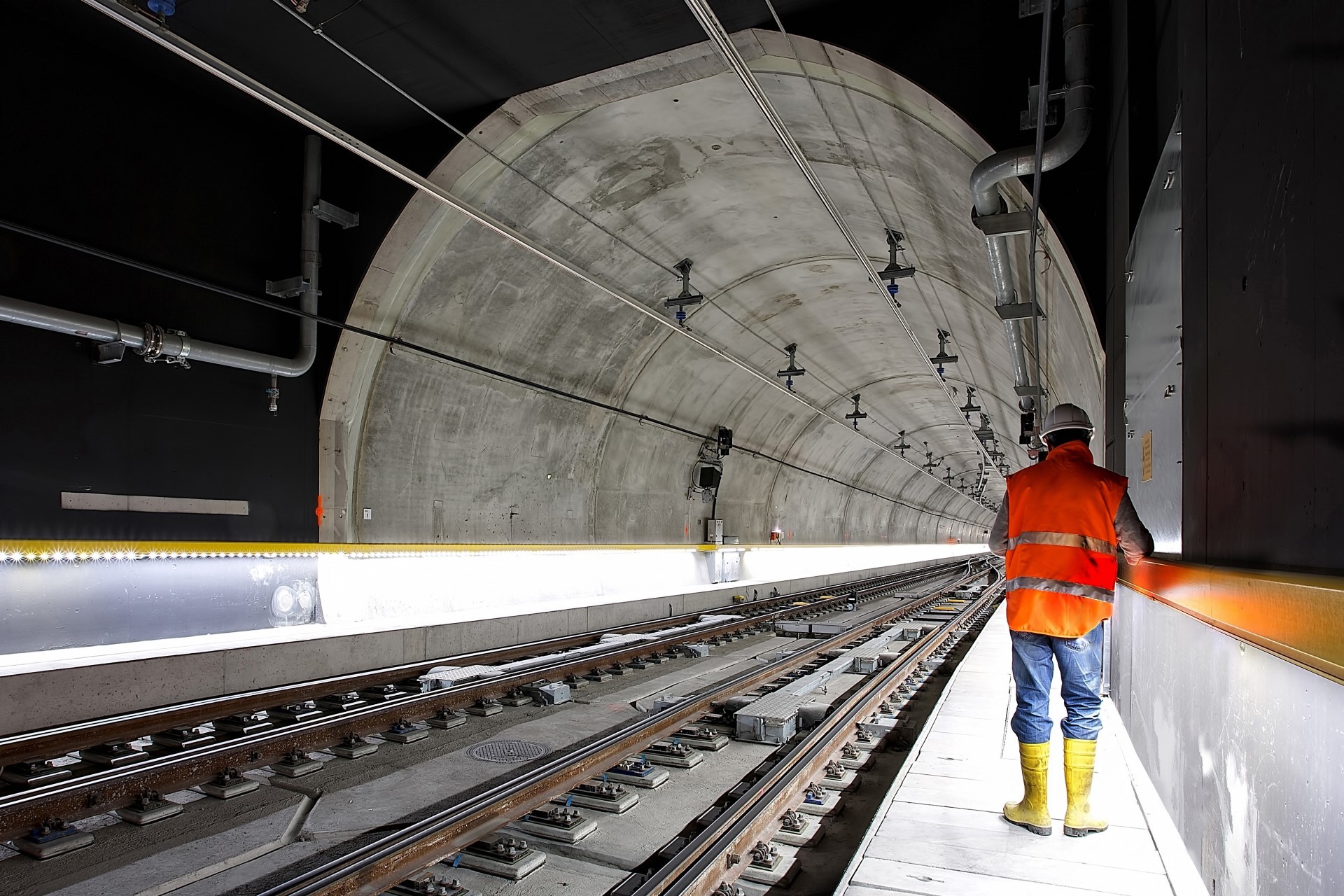 A photo of a worker entering a modern underground railway tunnel