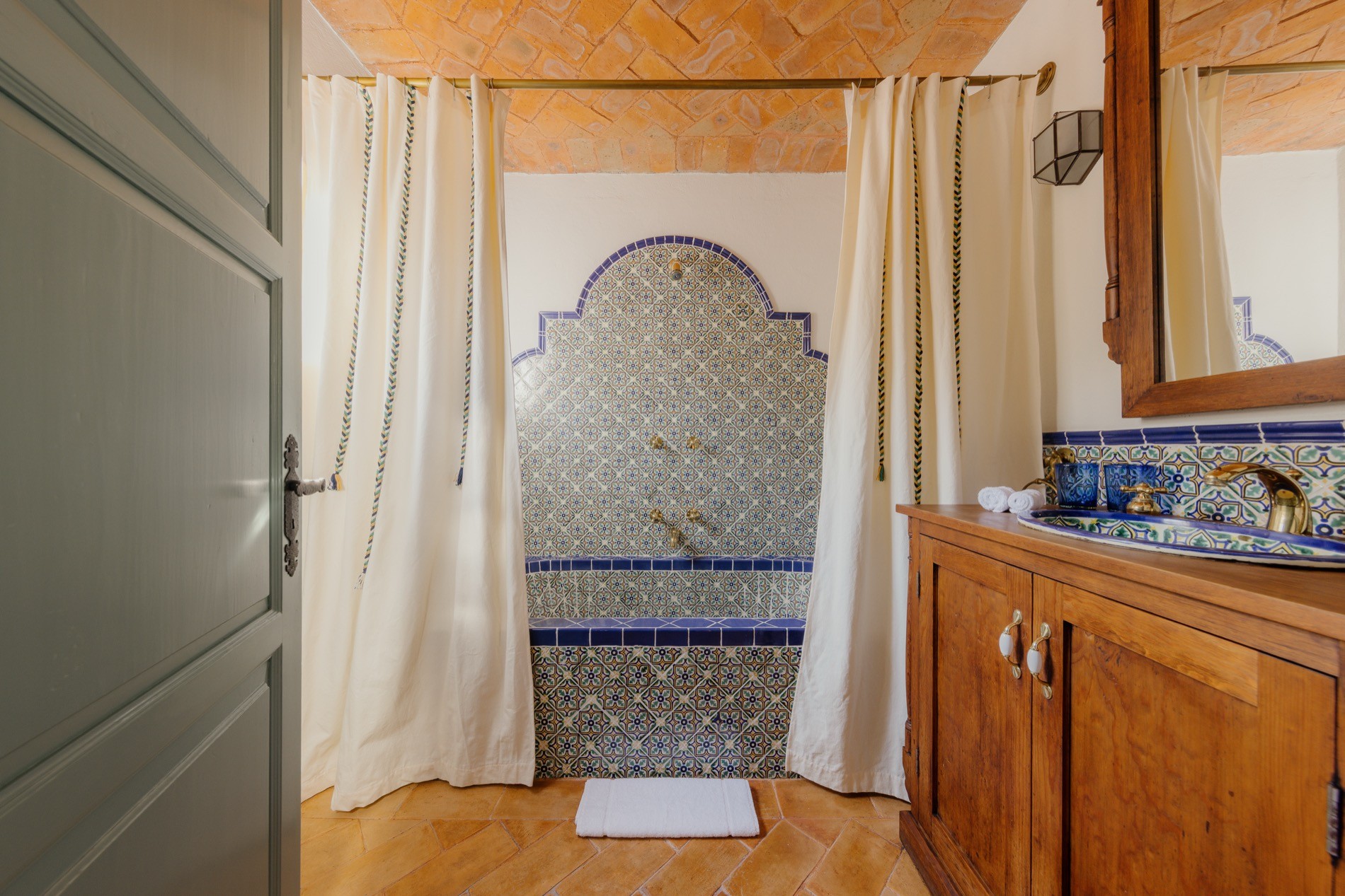 La Residencia walk-in shower with Talavera mosaic arch and herringbone brick ceiling