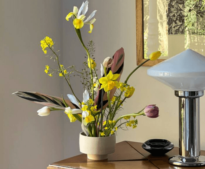 Composición floral por Irina Khatsernova con tulipanes y narcisos — diseño botánico de interior con flores de estación.