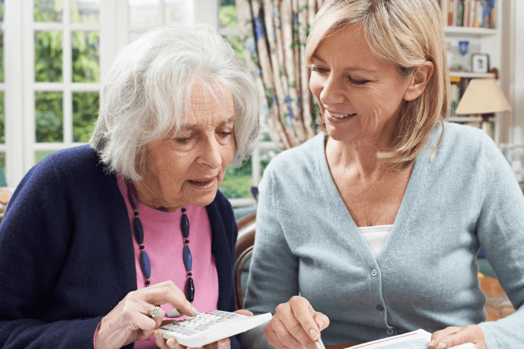 older woman is using a calculator with her daughter