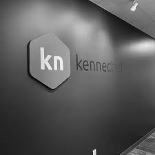 A lone figure in a hooded coat walks through a foggy, desolate landscape, evoking solitude and mystery in muted blue-gray tones.