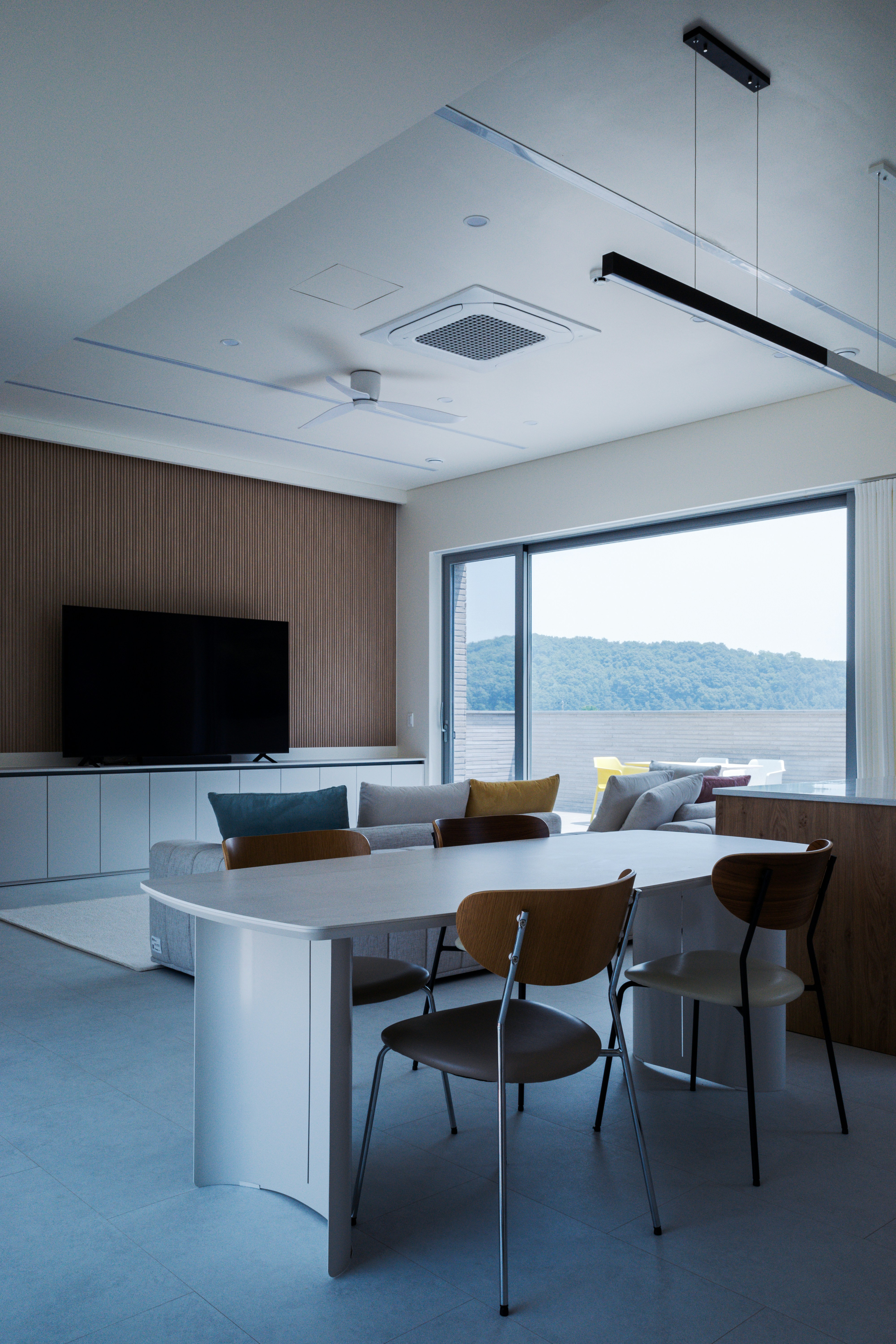 A room with a table, chairs and a television