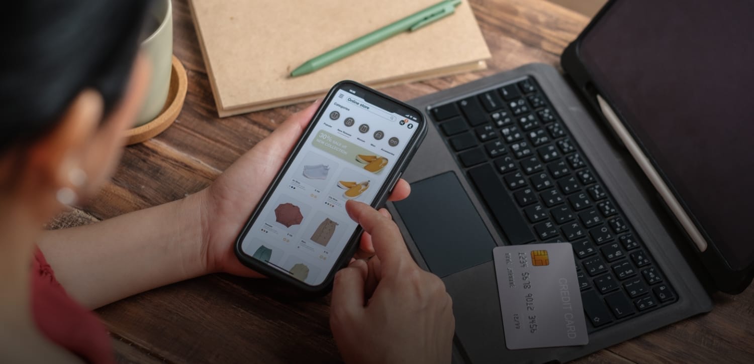 A man pulls a cleaning cart near a building.