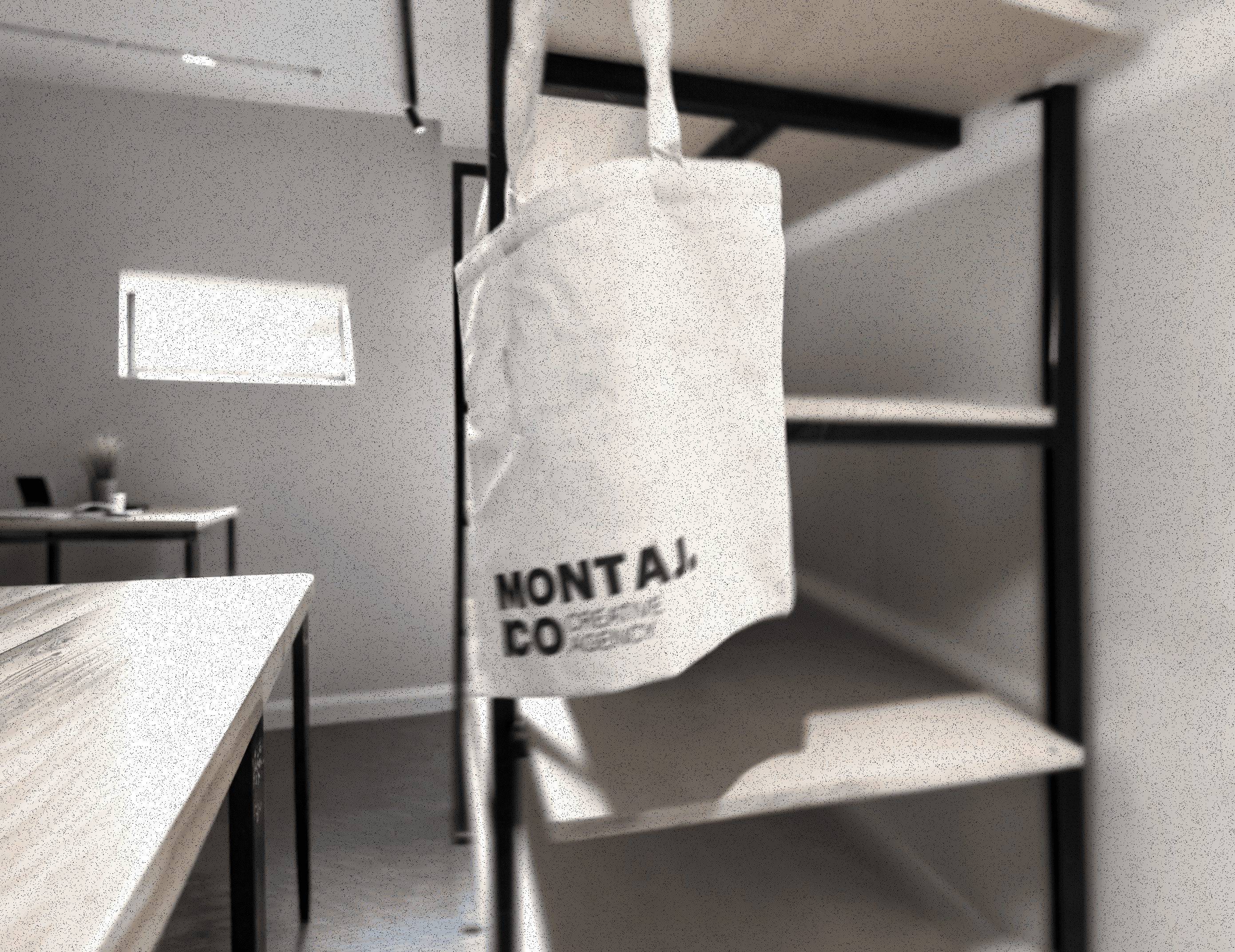 Black and white image of people working at a table with laptops, showing hands gesturing during discussion of digital content displayed on screens, with fabrica® logo in the corner.