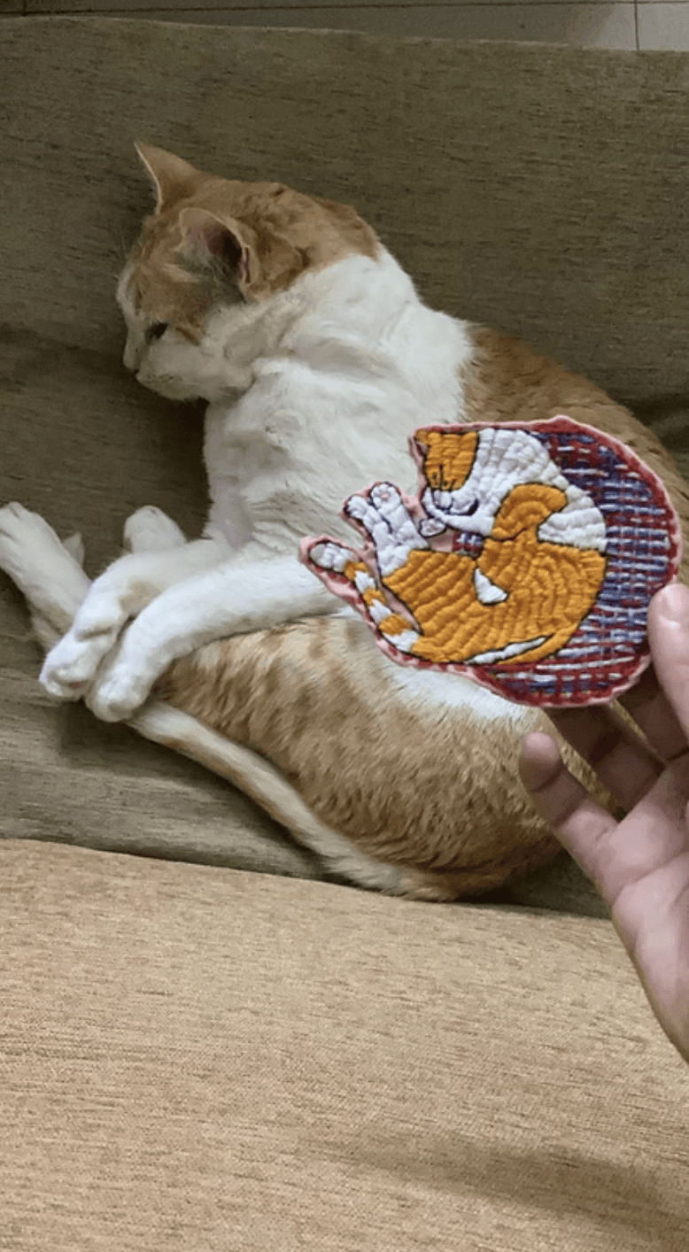 A person stands outdoors in a natural setting with lush green trees under a clear sky, wearing a dark sweatshirt, and looking into the distance.