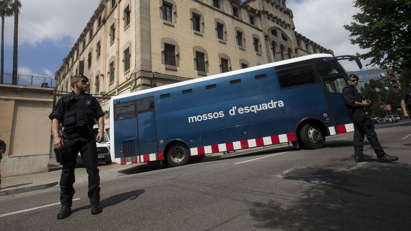 un vehiculo de mossos d'esquadra y dos mossos vigilando la periferia