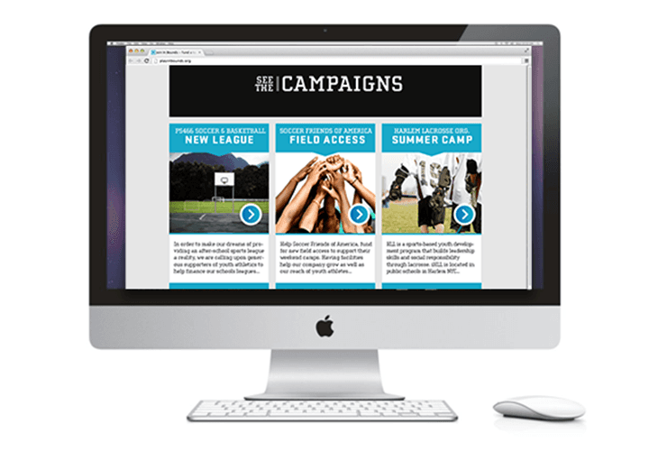 A silver Apple iMac computer displays a webpage titled “SEE THE CAMPAIGNS” with three campaign sections: “NEW LEAGUE,” “FIELD ACCESS,” and “SUMMER CAMP.” Each section features images and text describing initiatives. The webpage is accessed via a browser’s address bar and includes a white Apple keyboard and mouse.