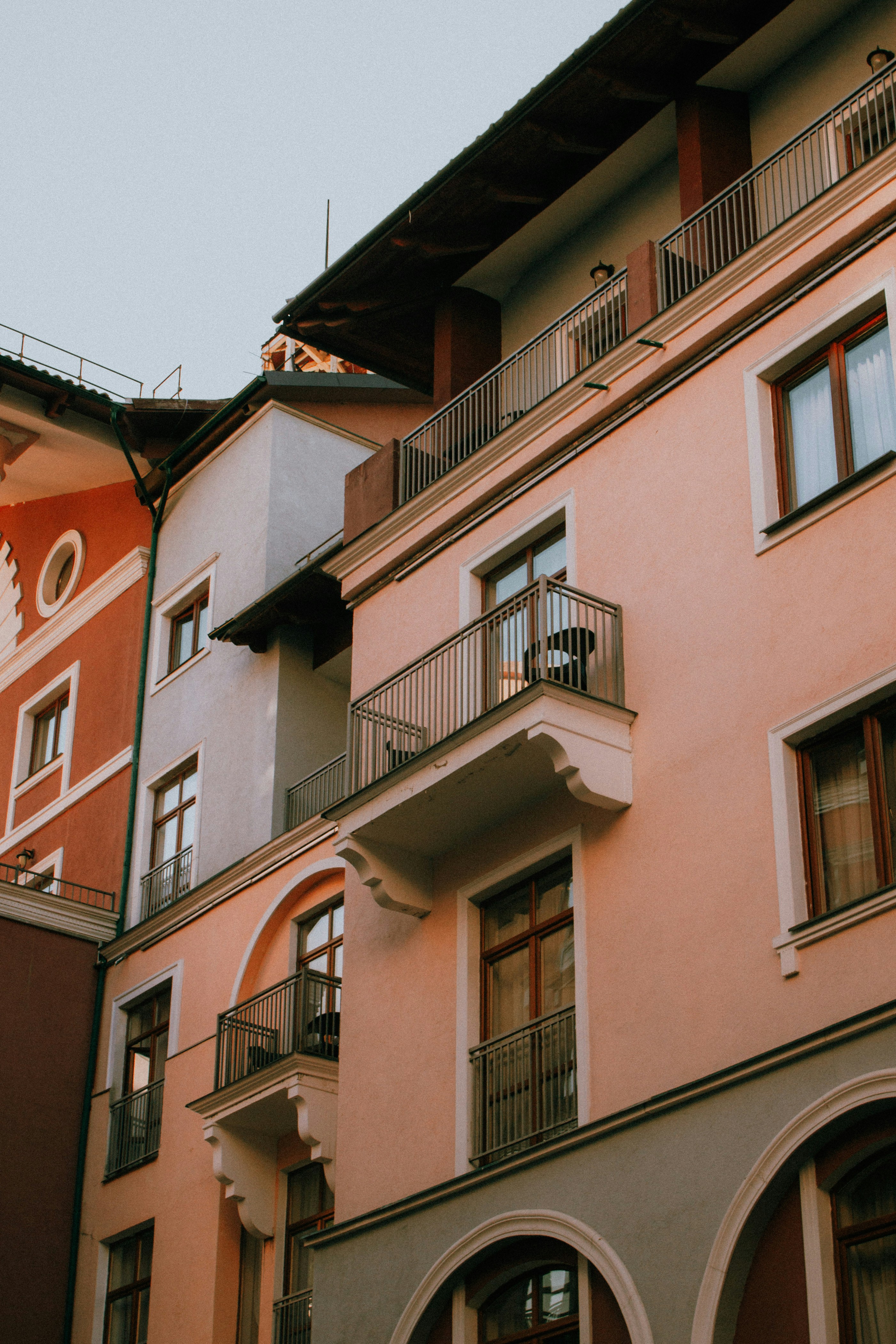 a tall pink building with balconies and balconies