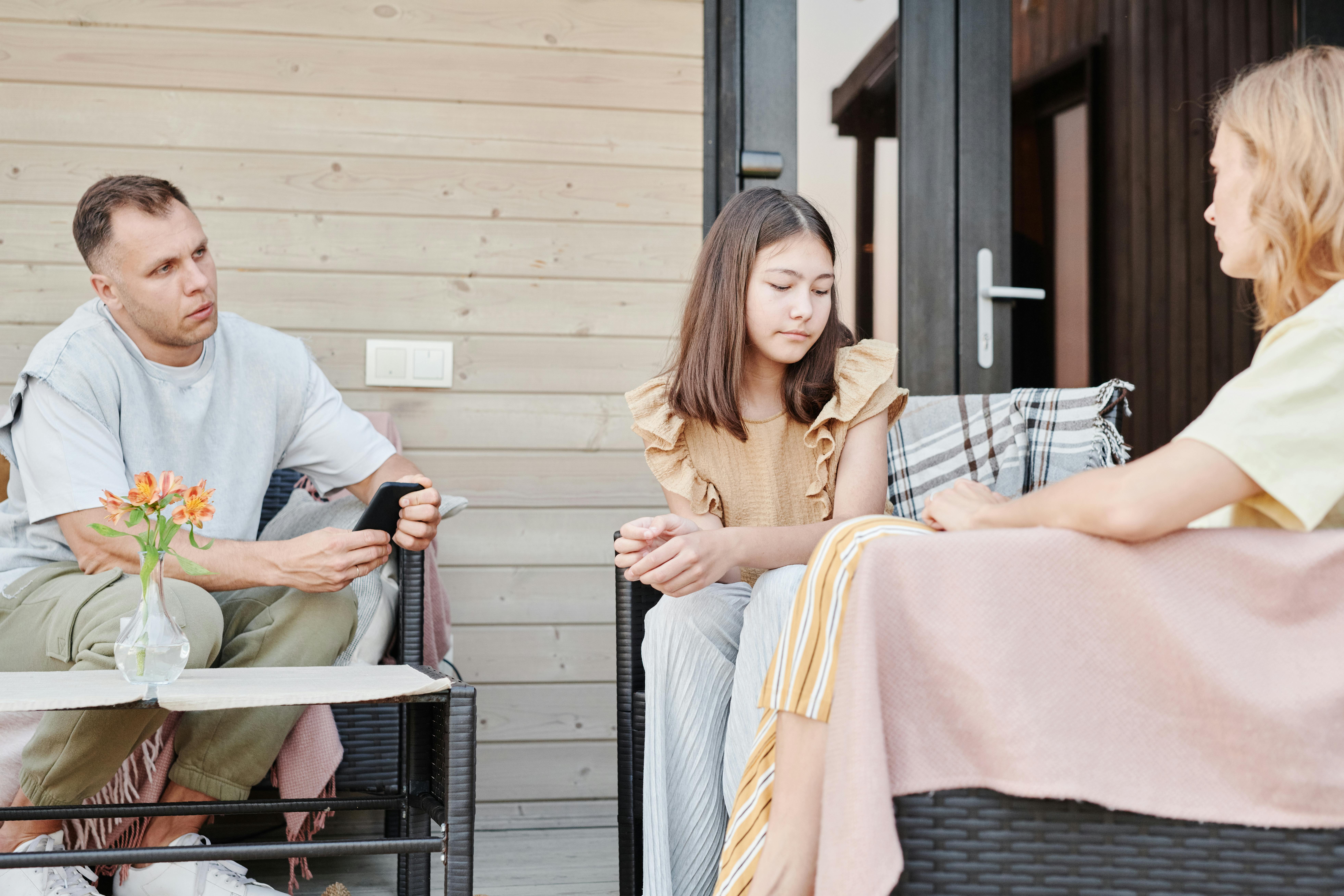 Conversion Truth for Families - Father and mother sitting outside on chairs talking to teen daughter