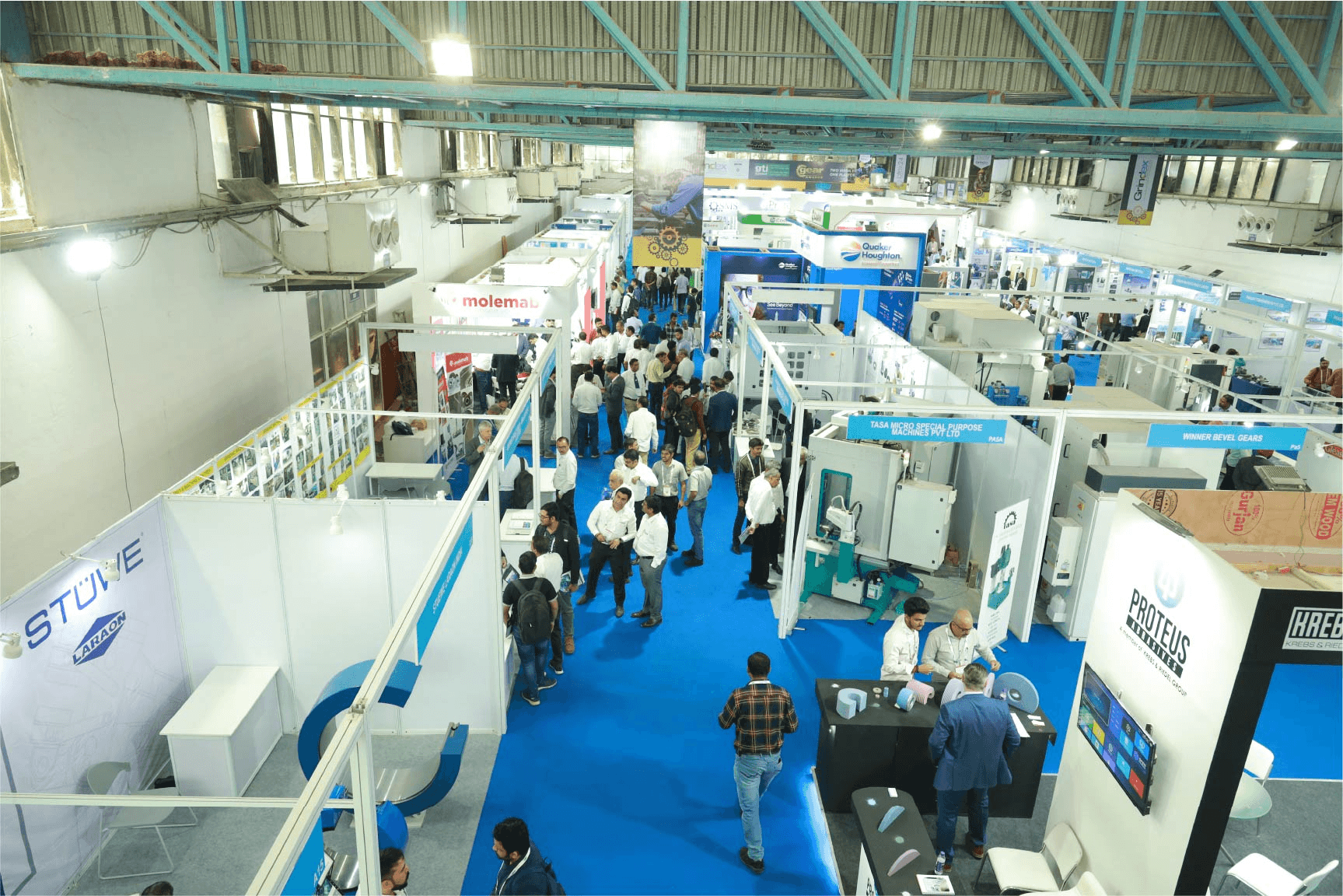 Busy industrial trade show floor at IPTEX 2026 in Pune with power transmission manufacturers, OEM buyers, and machinery displays