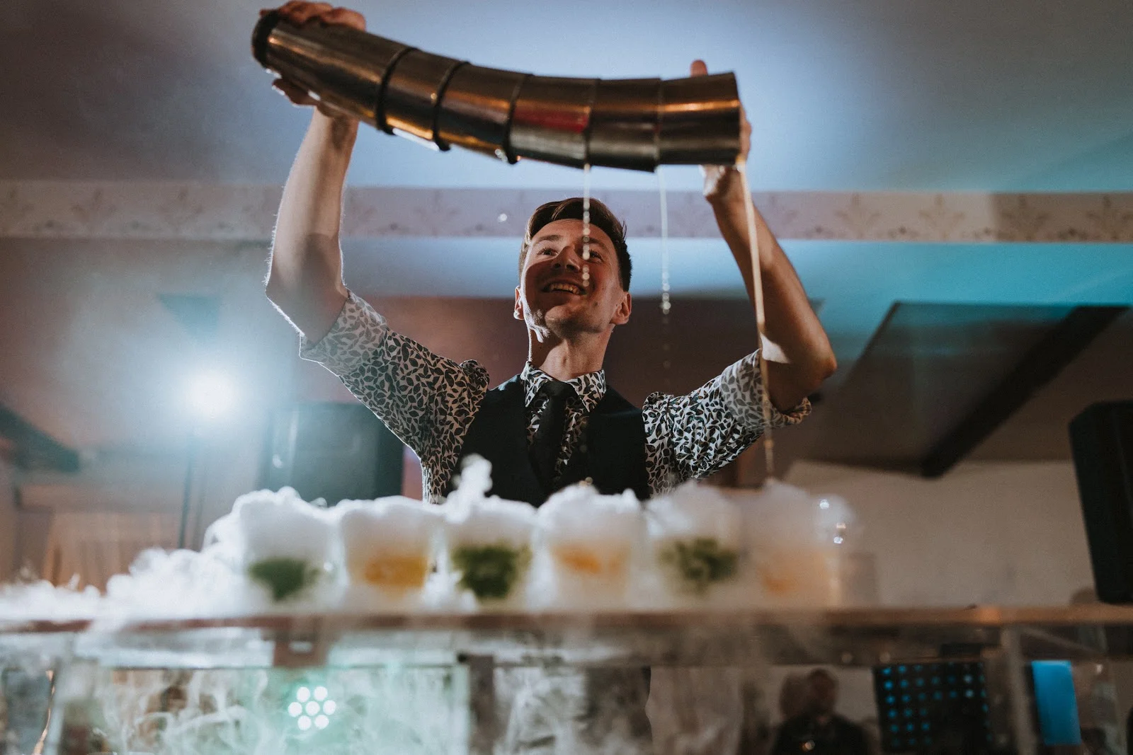 Barman na wesele prowadzący pokaz barmański, zachwycający gości.