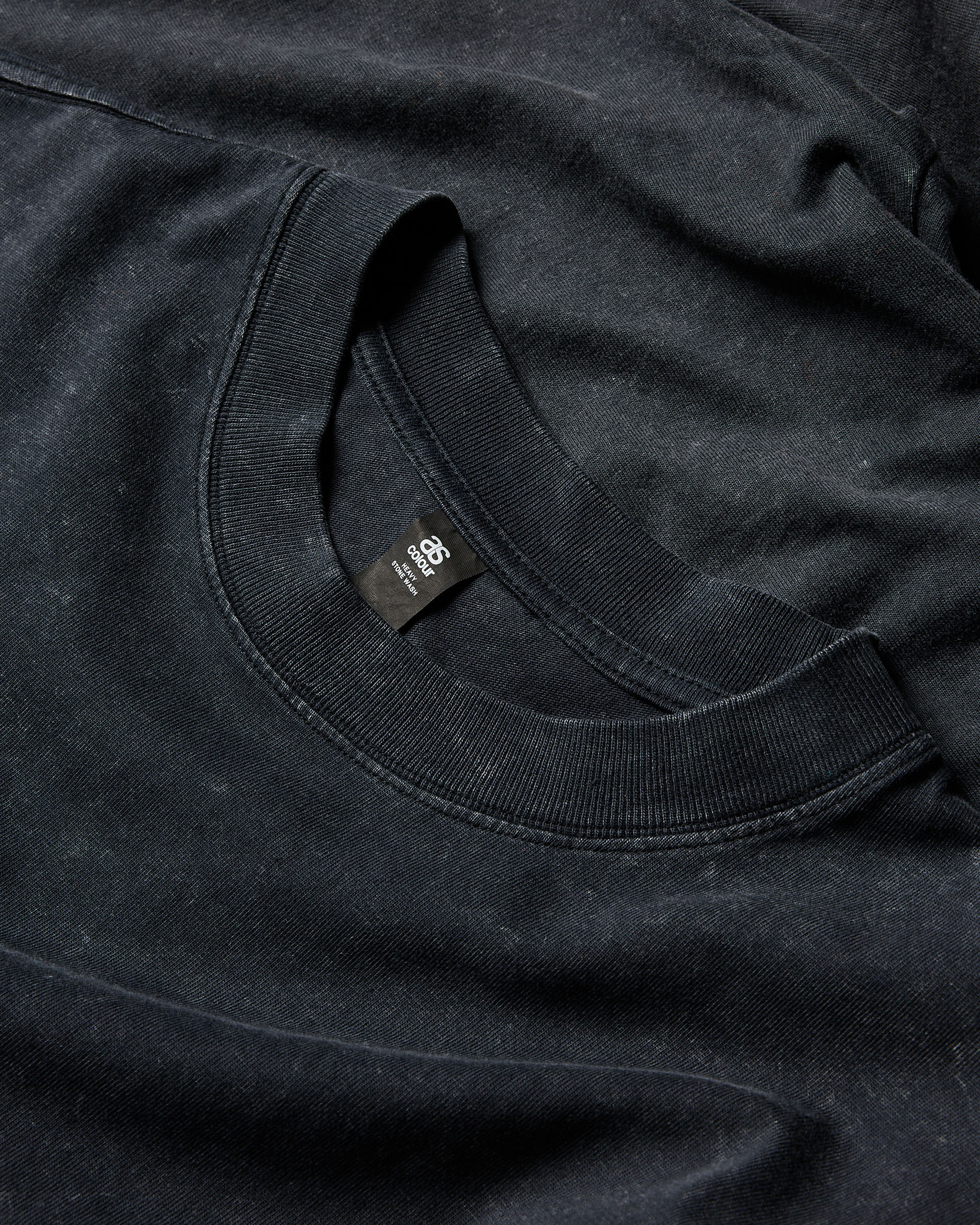 Close-up of a black tee neckline and label