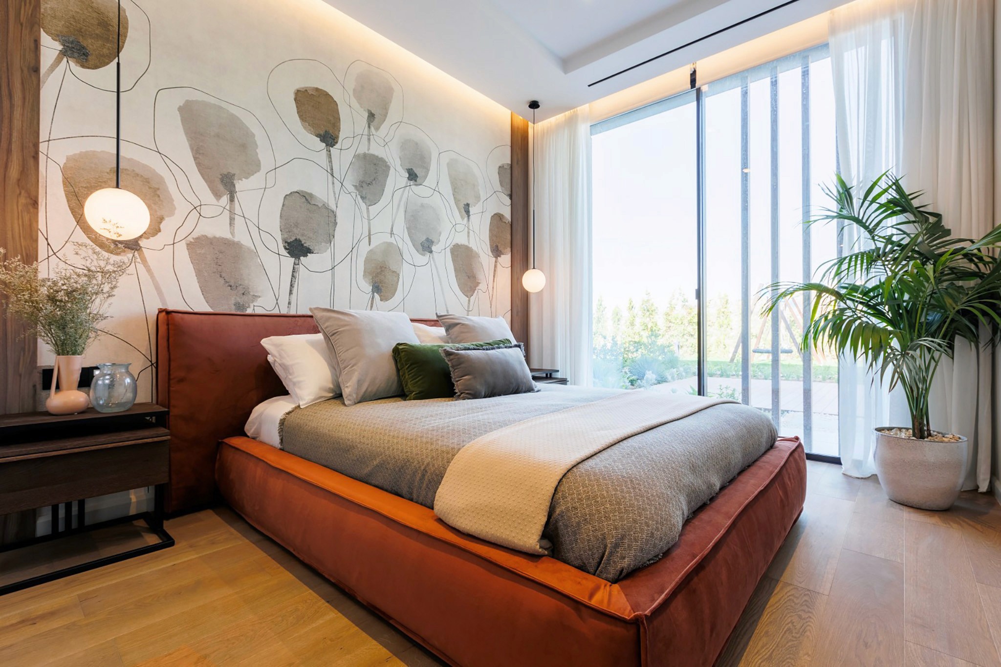 Villa Trio bedroom with statement wall mural, leather-upholstered bed, and floor-to-ceiling glazing