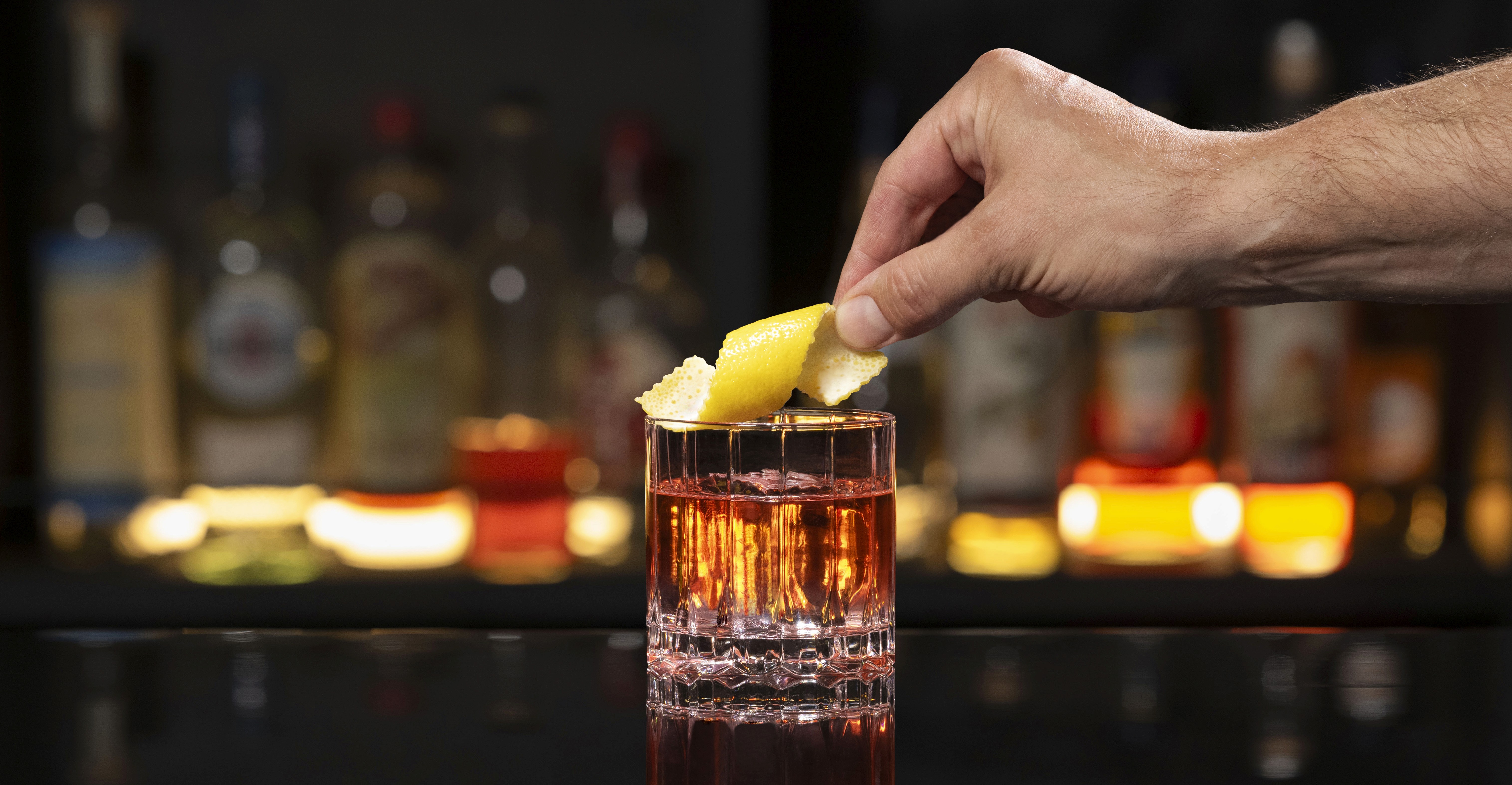 A NEFT Barrel and a glass of Sazerac on a bar counter.