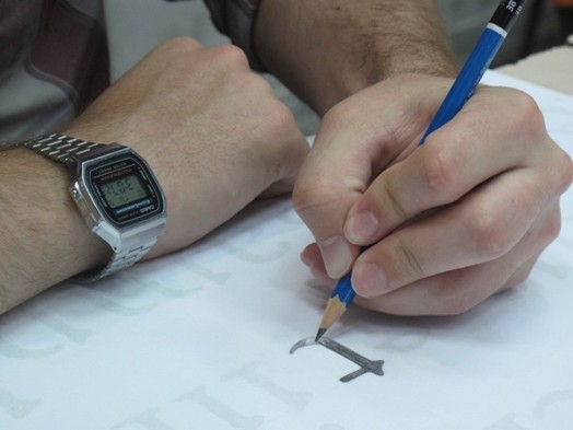 A photo of a letter being drawn by a student on a piece of paper.