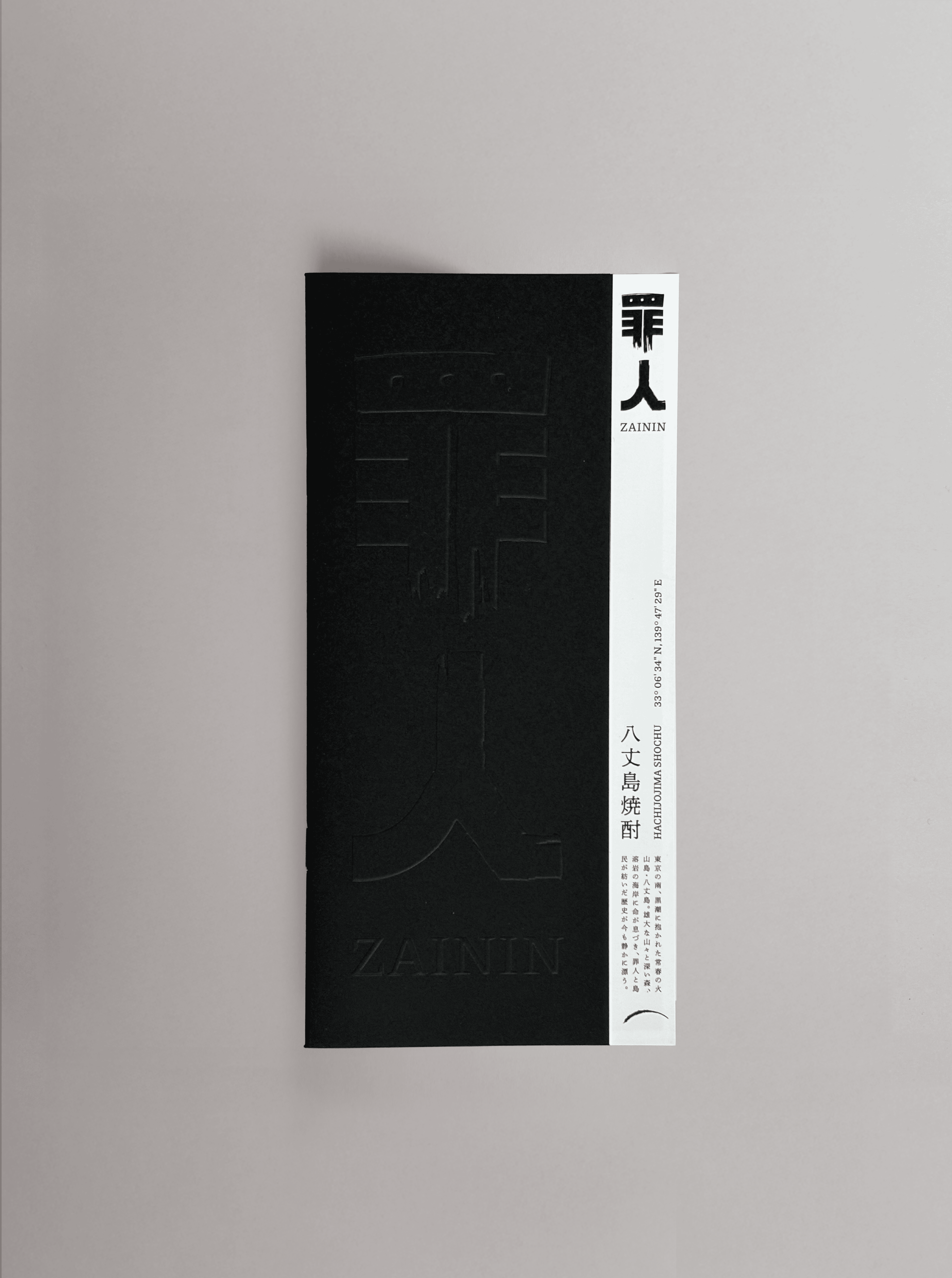 Zainin black embossed leflet displayed on a grey background.