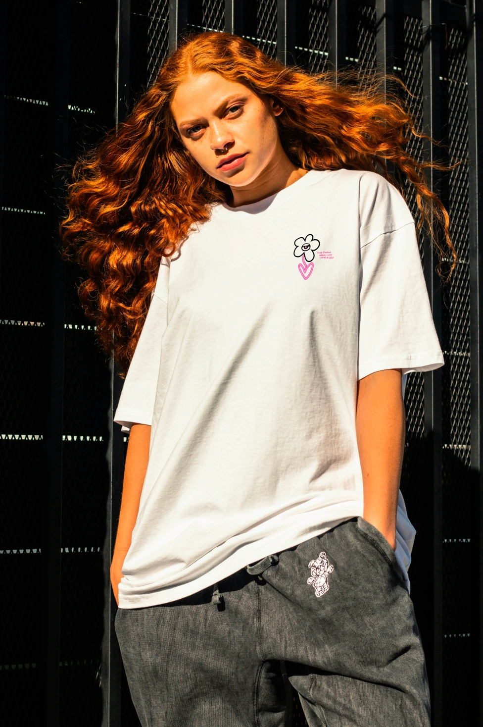 Femme rousse vêtu d'un tee shirt blanc avec un motif imprimé 