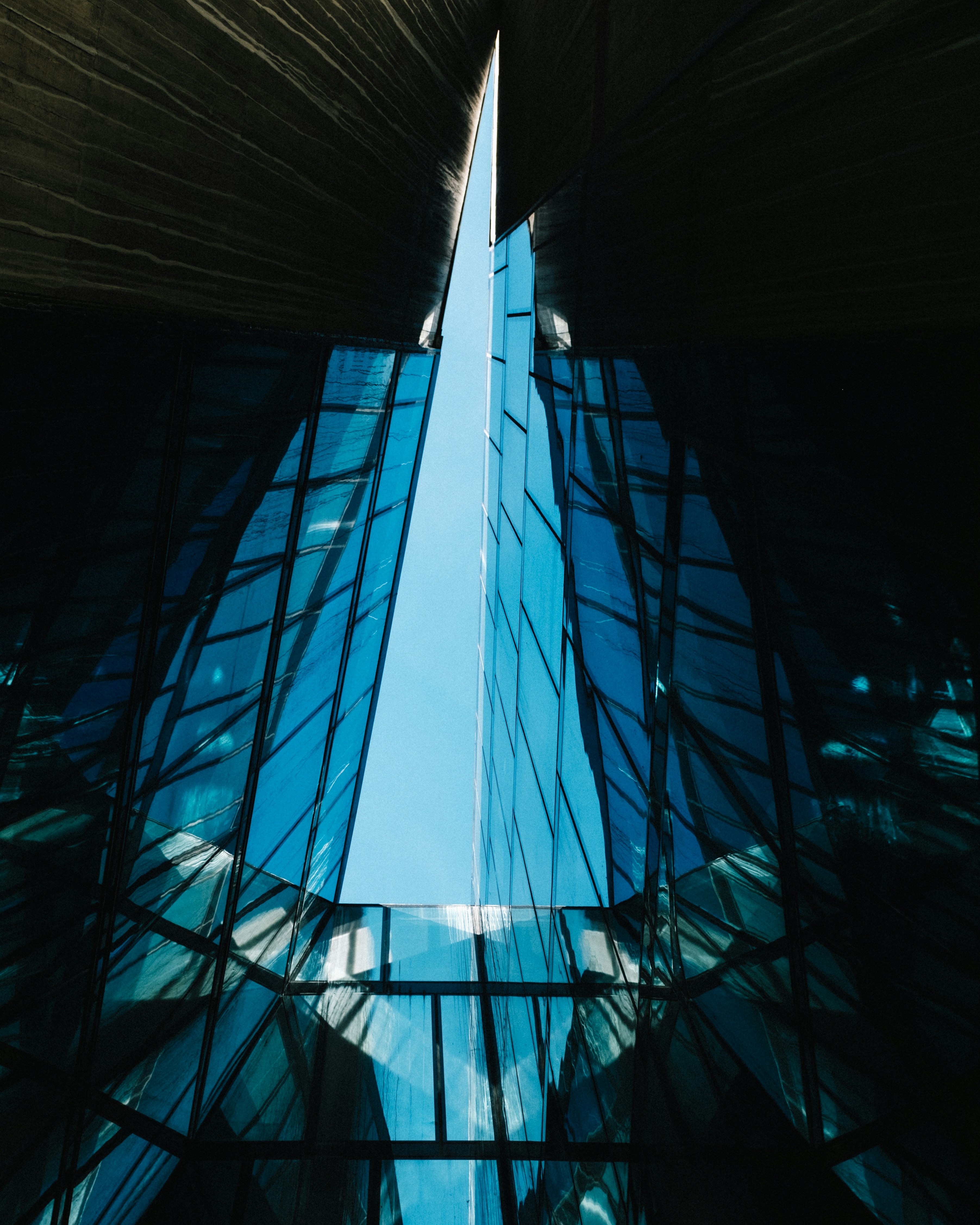 Modern glass skyscraper reflecting blue sky