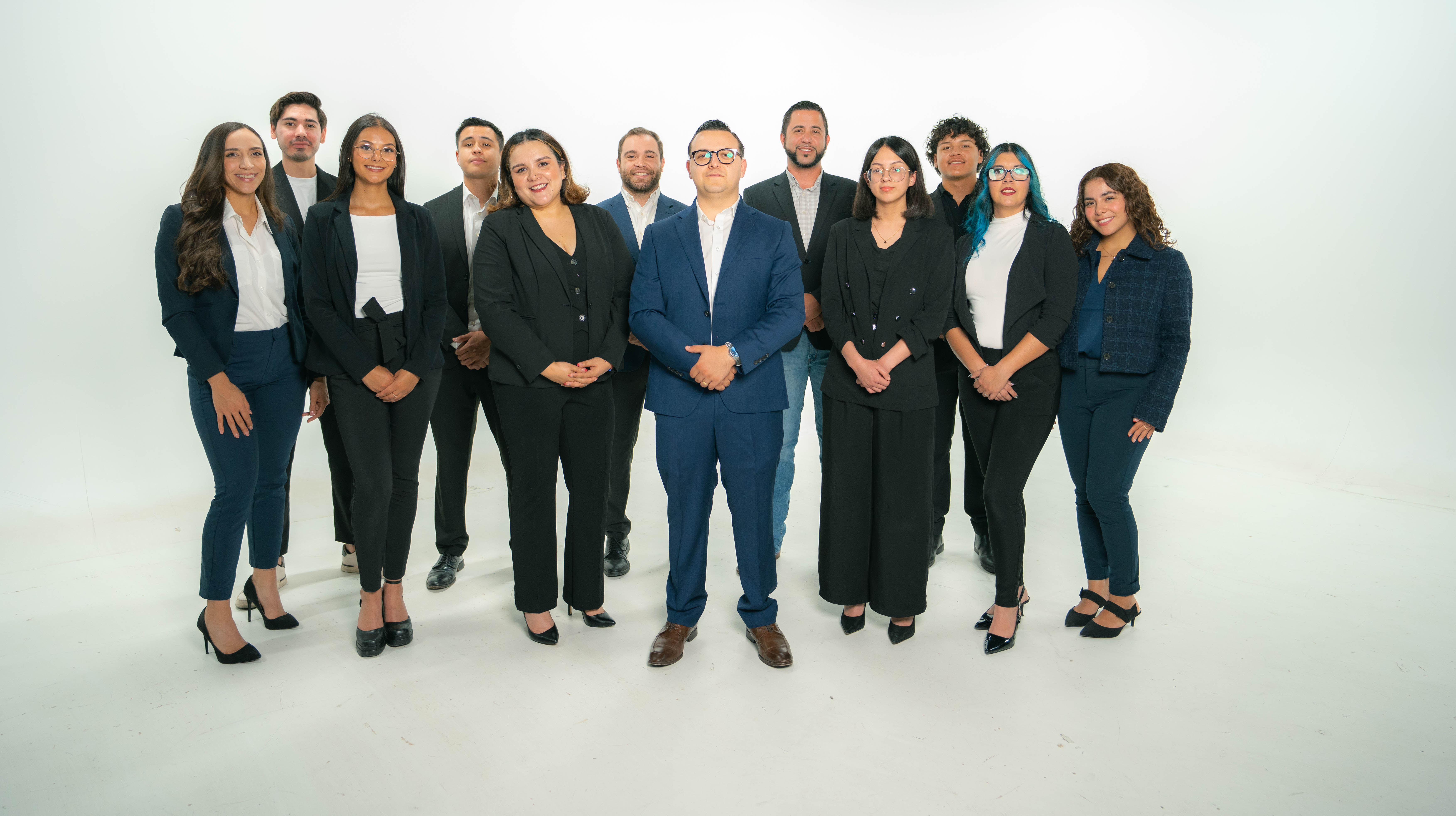 Black and white image of people working at a table with laptops, showing hands gesturing during discussion of digital content displayed on screens, with fabrica® logo in the corner.