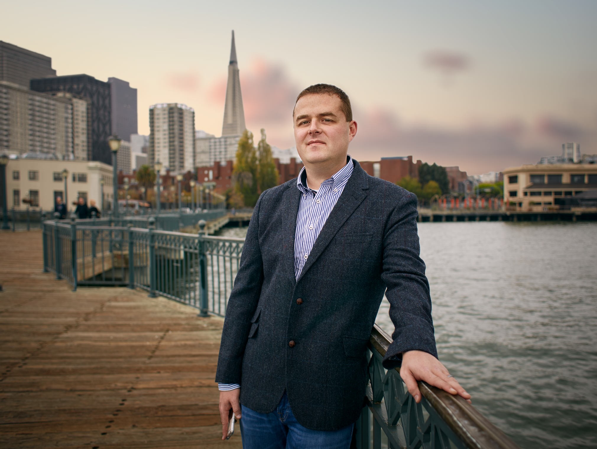 Professional portrait of man in blazer on San Francisco waterfront with Transamerica Pyramid in background