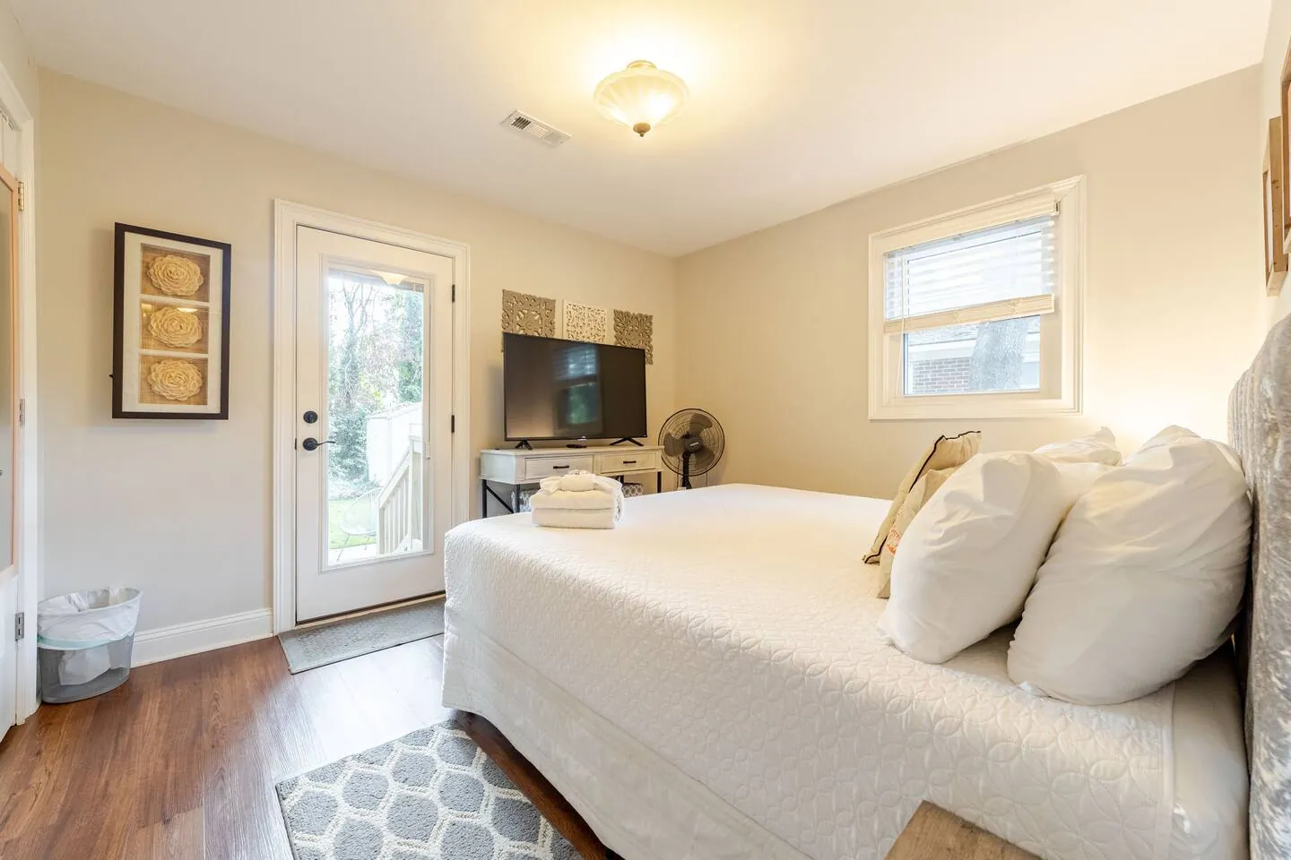 Bedroom with a glass door to the backyard and a TV on the dresser
