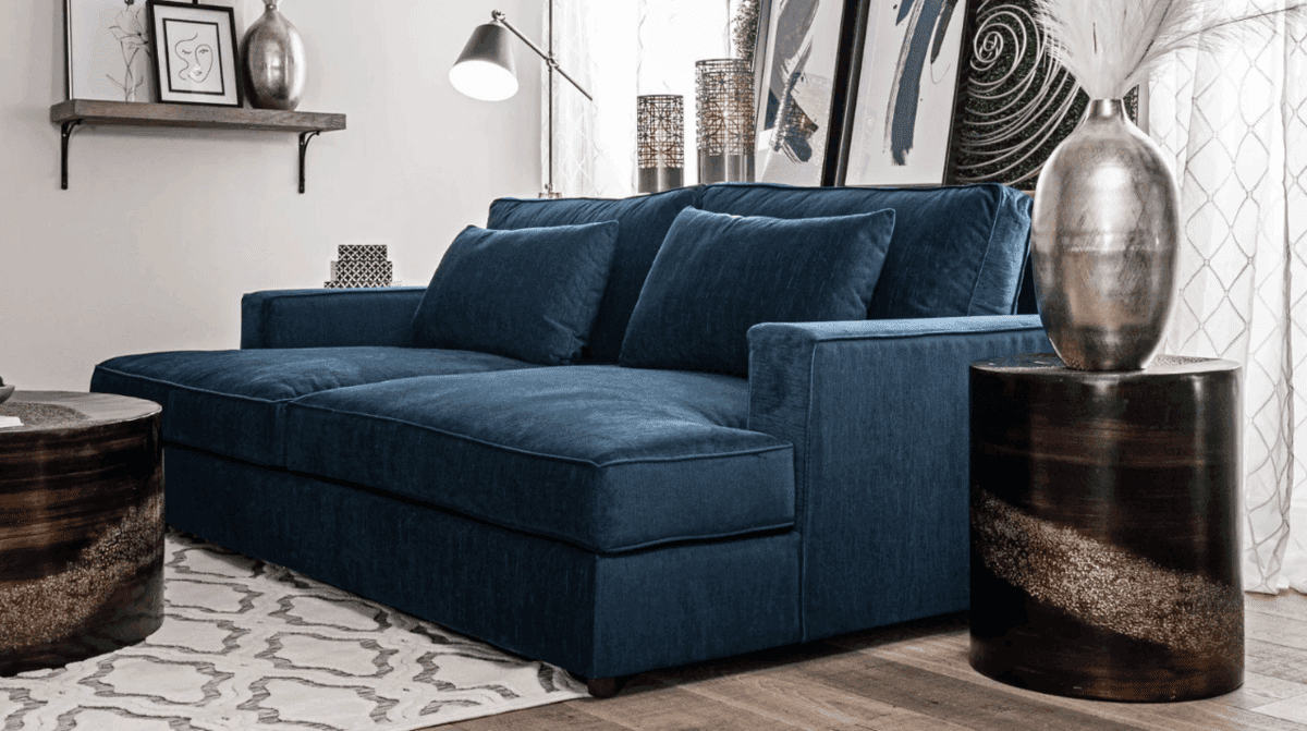 Deep blue Bailey 96" square arm sofa with reversible cushions, surrounded by contemporary decor elements.